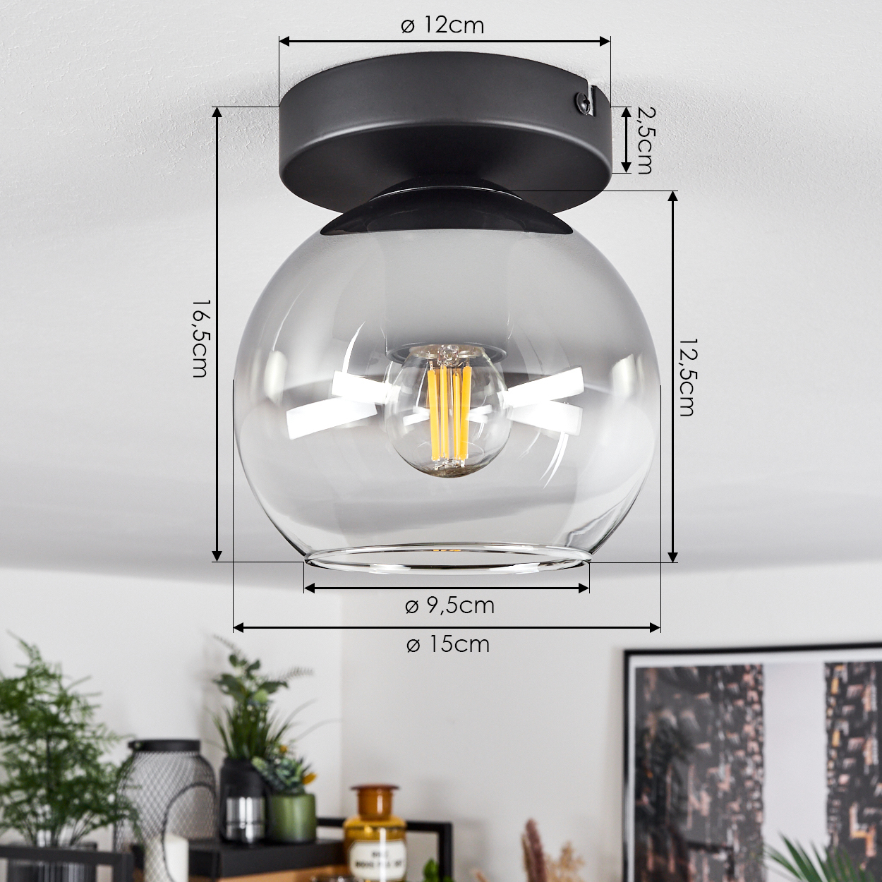 Deckenlampe mit rauchiger Glaskugel und schwarzem Sockel, mit Abmessungen. Innenraum mit Pflanzen und Dekoration.