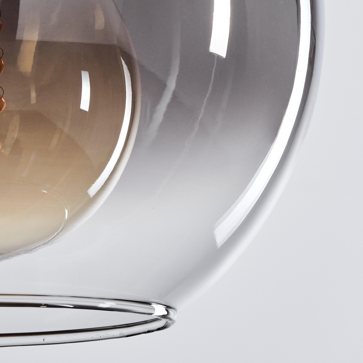 Nahaufnahme der Glaskugel einer Lampe, die einen Farbverlauf von hell nach dunkel zeigt.