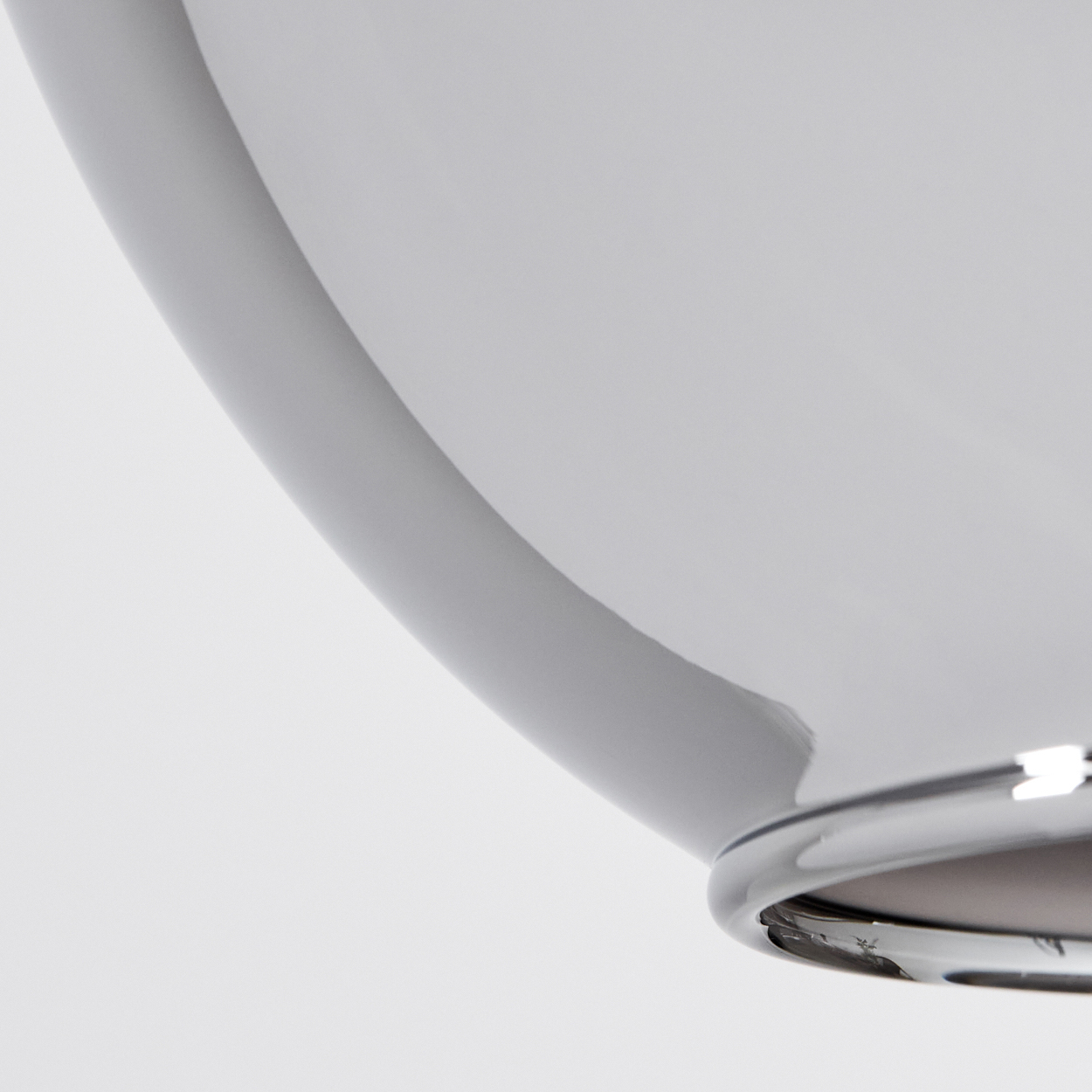 Nahaufnahme einer verspiegelten Glaskugel, die Krümmung des Glases reflektiert helles Licht.