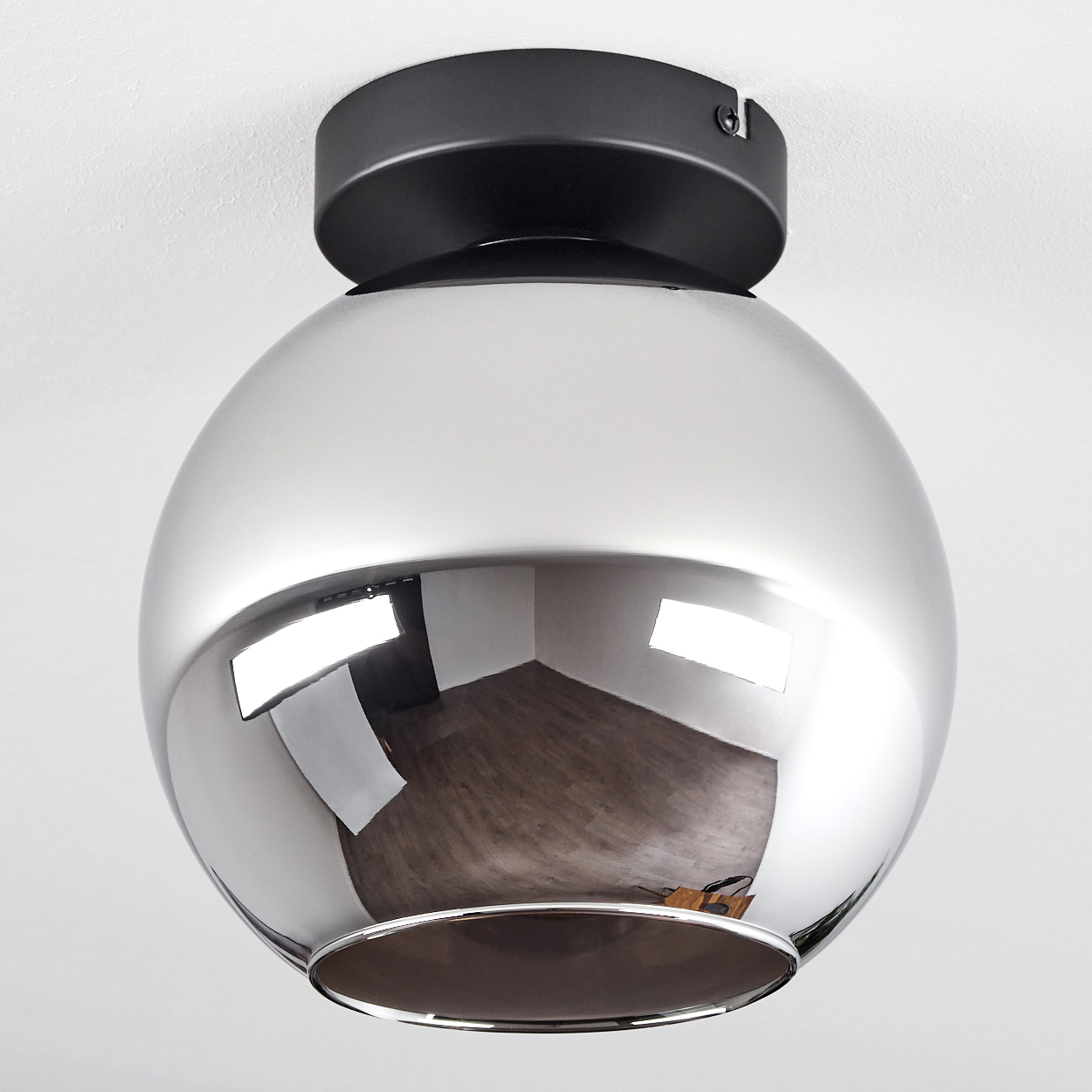 Deckenlampe mit verspiegelter Kugel, die den Raum und seinen Inhalt mit einer weißen Decke reflektiert.