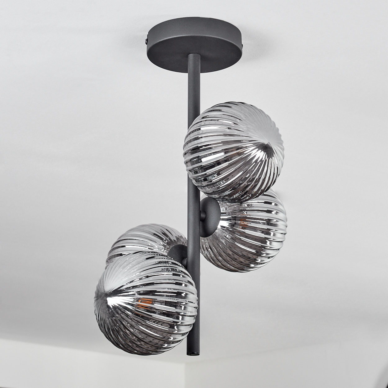 Eine moderne Leuchte mit vier Glaskolben. Die Kolben haben ein wellenförmiges Design.