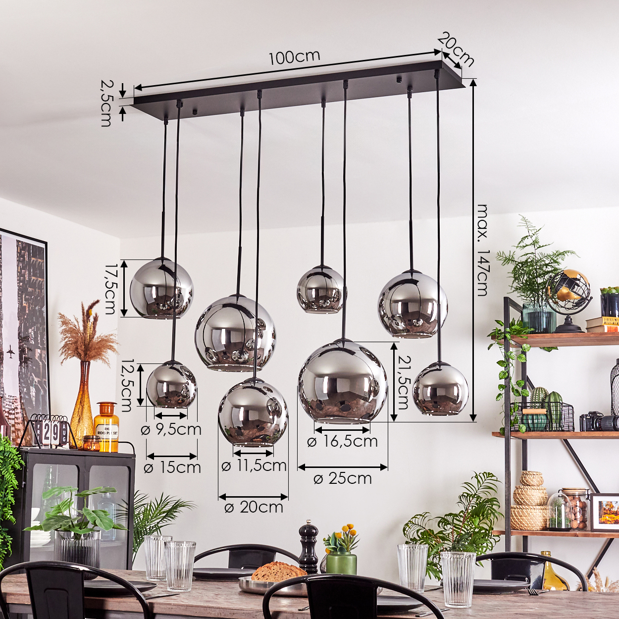 Ein Esszimmer mit kugelförmigen Pendelleuchten, die von der Decke hängen, mit beschrifteten Abmessungen.