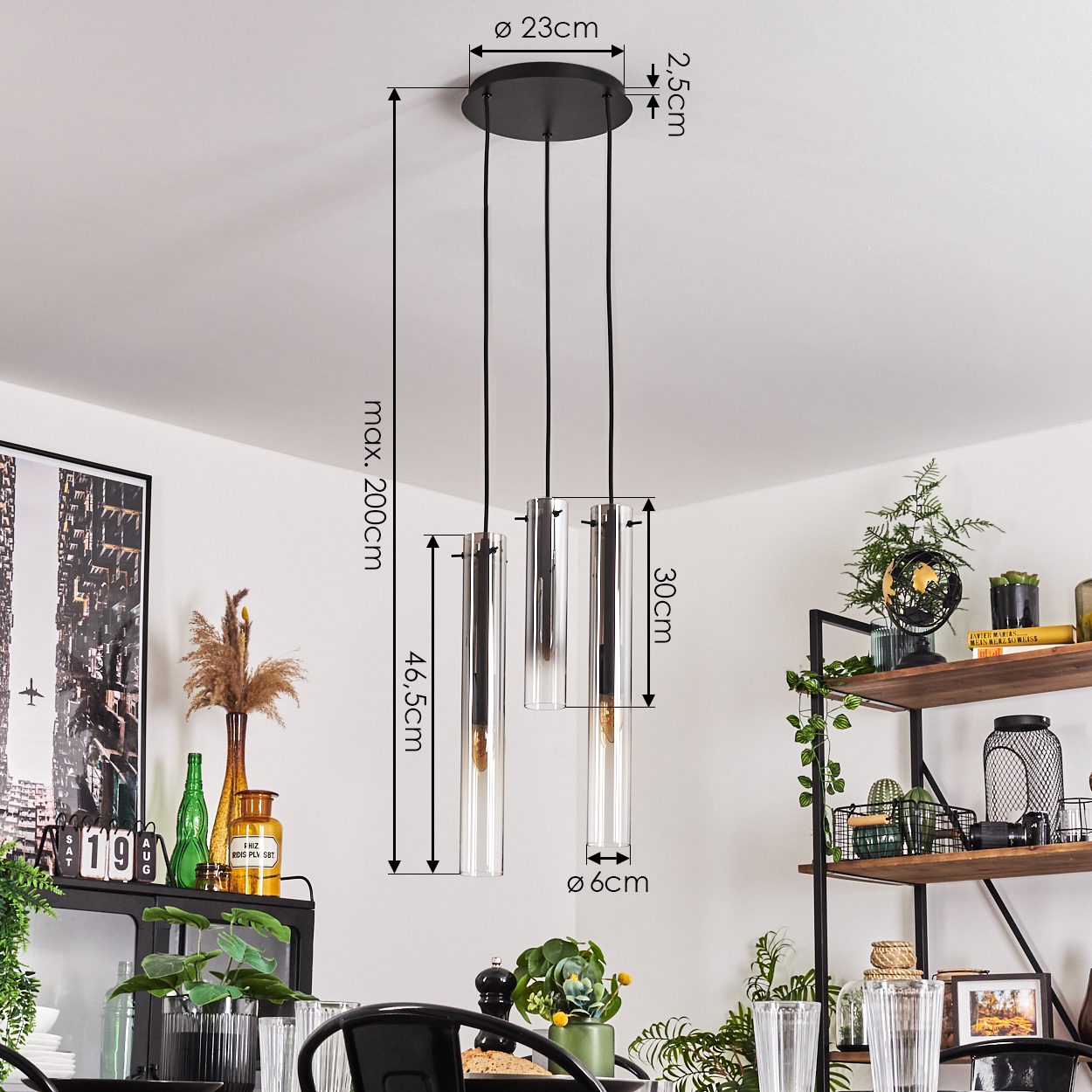 Ein Esszimmer mit drei Pendelleuchten. Die Leuchten haben zylindrische Glasschirme und hängen von der Decke.