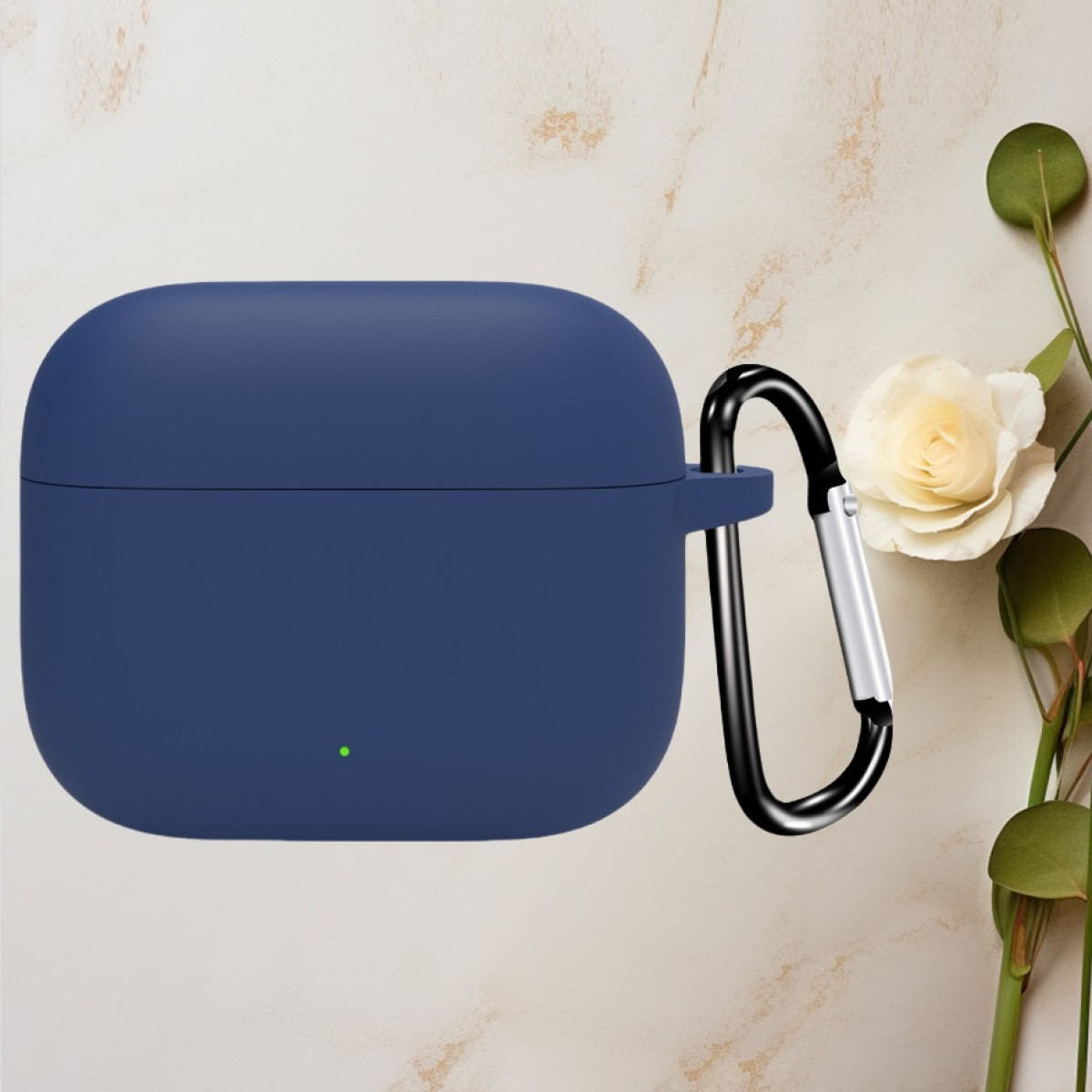 Marineblaues Kopfhörer-Etui mit schwarzem Karabinerhaken. Im Hintergrund eine weiße Blume und grüne Blätter.
