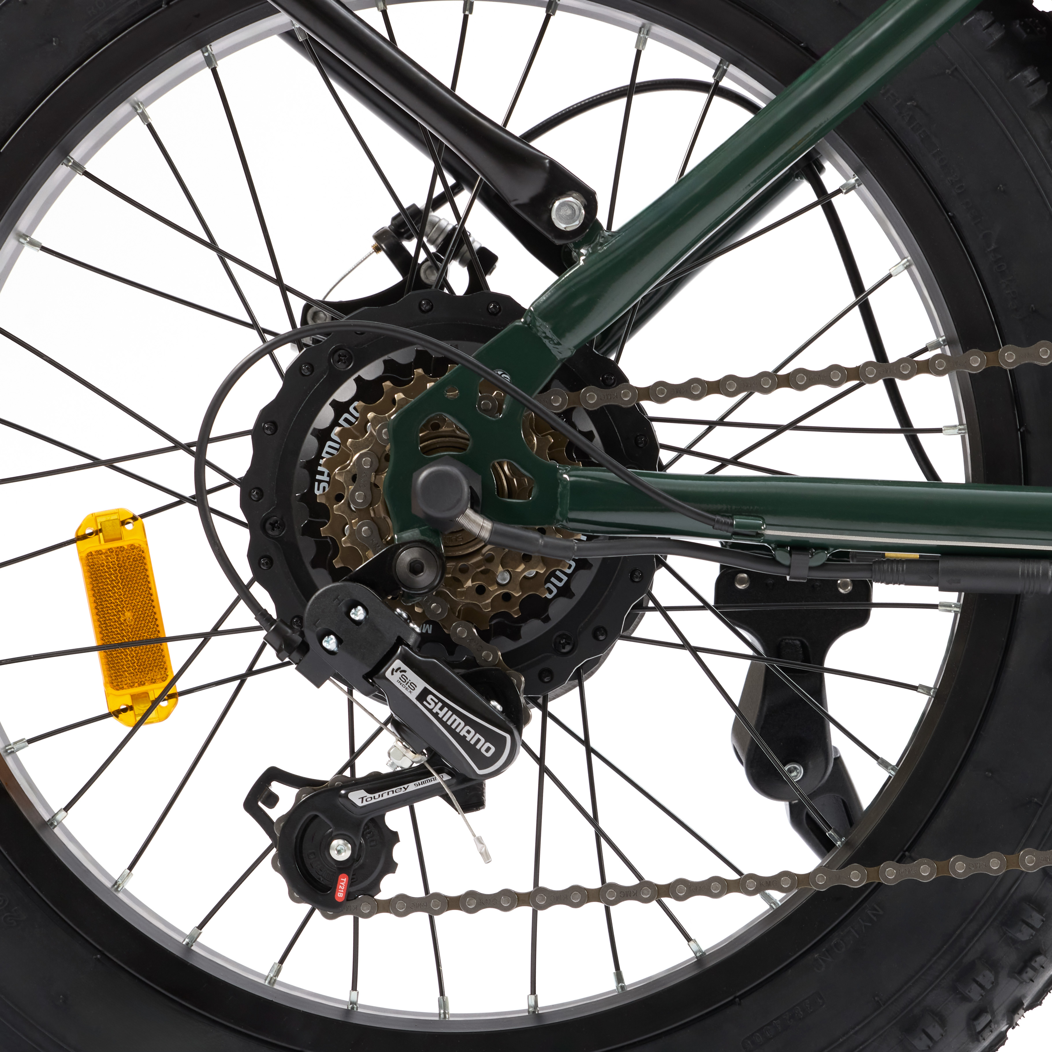 Zbliżenie koła roweru z ciemnozieloną ramą i różnymi przełożeniami i komponentami.