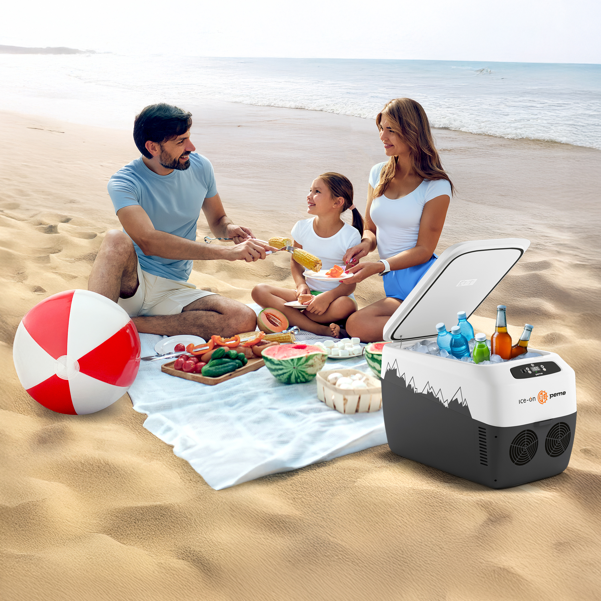 Familie bei einem Strandpicknick mit Essen, Getränken, einer Kühlbox und einem Strandball. Blaues Meer im Hintergrund, sonniger Tag.