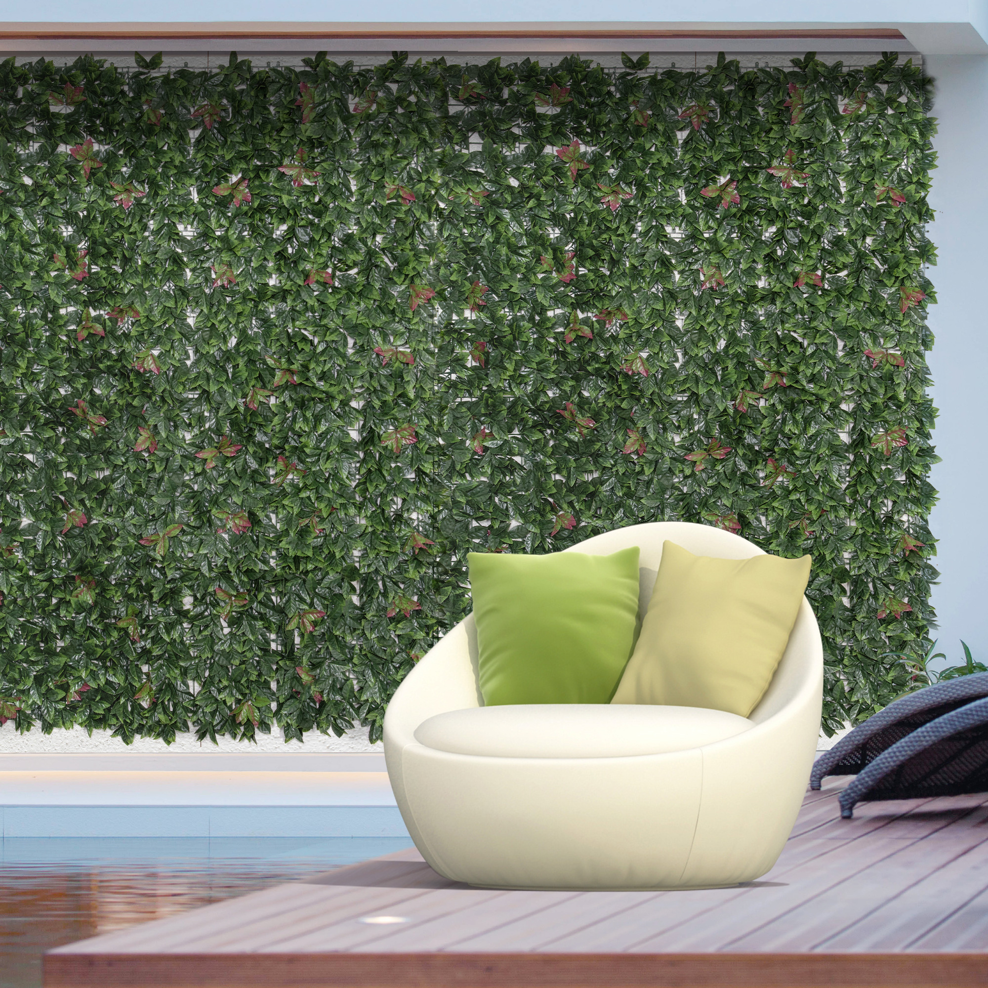 Weißer Stuhl mit grünen und gelben Kissen vor grüner Wand. Pool und Holzdeck sichtbar.