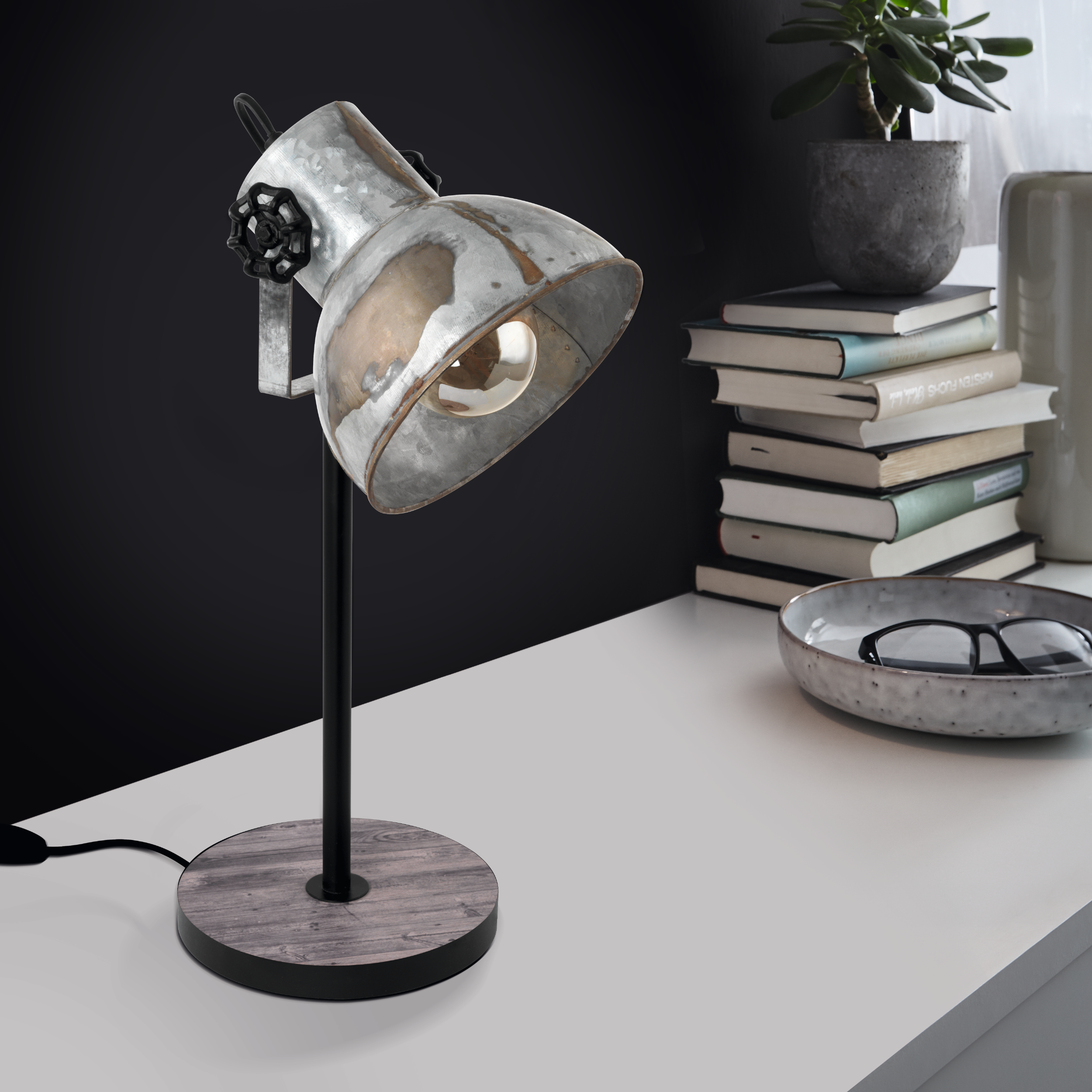Metall-Schreibtischlampe mit abgenutztem Finish, verstellbarem Kopf, auf weißer Oberfläche.