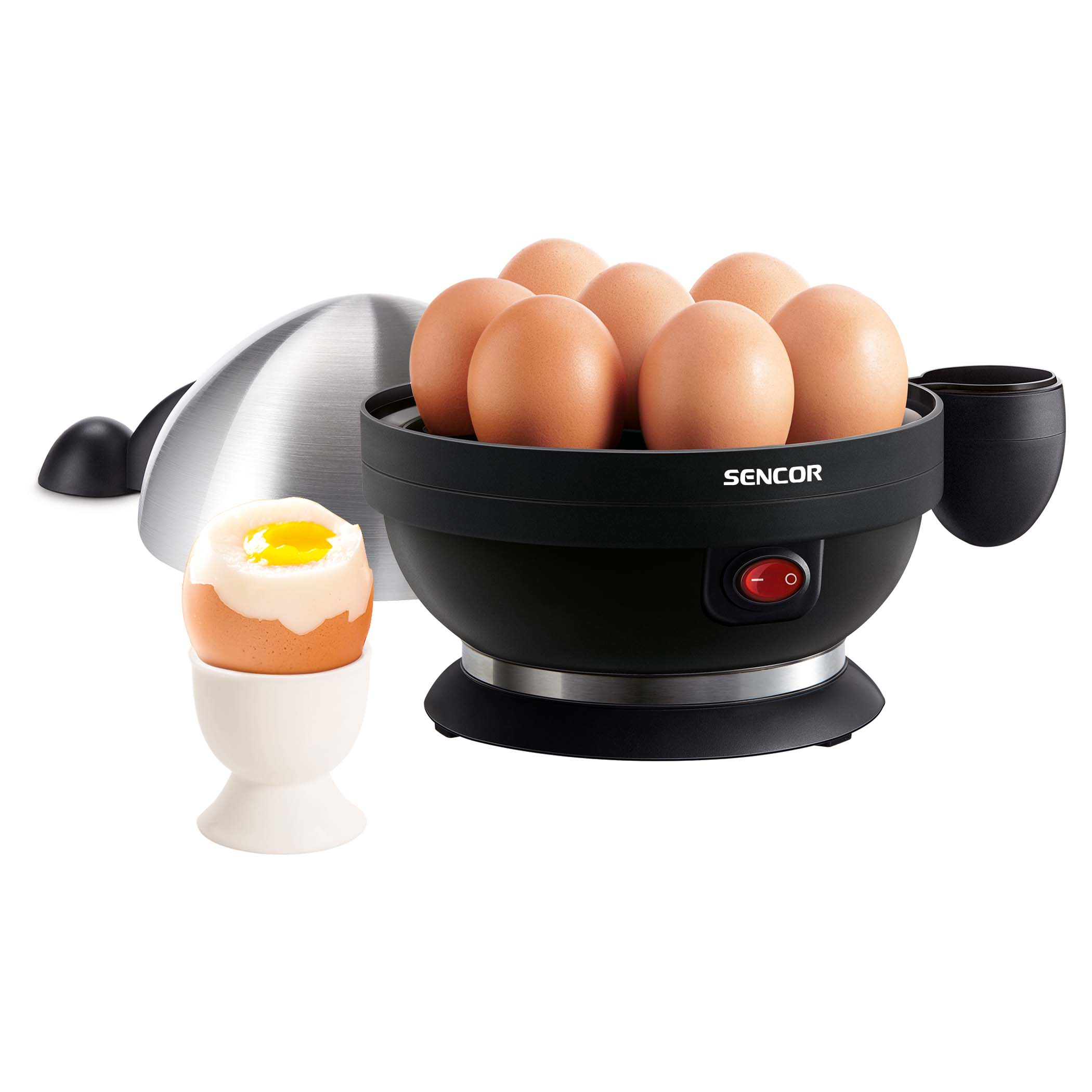 An egg cooker with eggs. An egg is in a white cup. Silver lid is to the side.