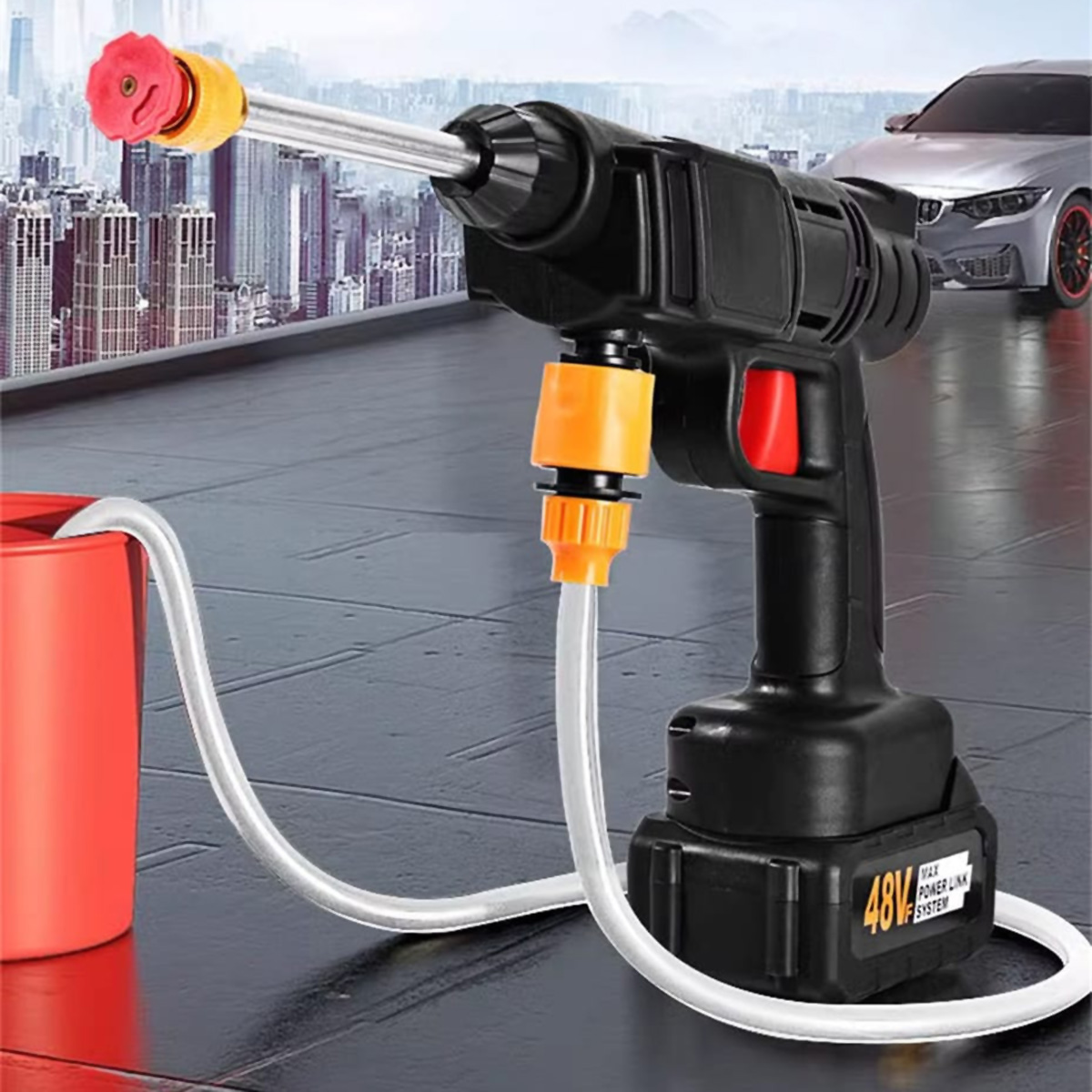 Hidrolimpiadora portátil negra y roja con accesorios. Coche y ciudad al fondo. Cubo rojo y manguera de agua.
