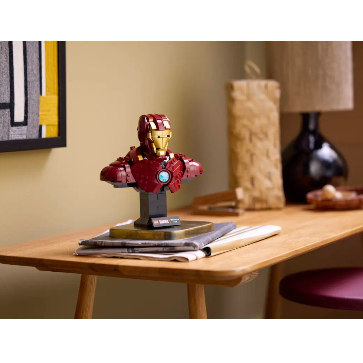 Model popiersia Iron Mana na stole, książki i mała figurka.