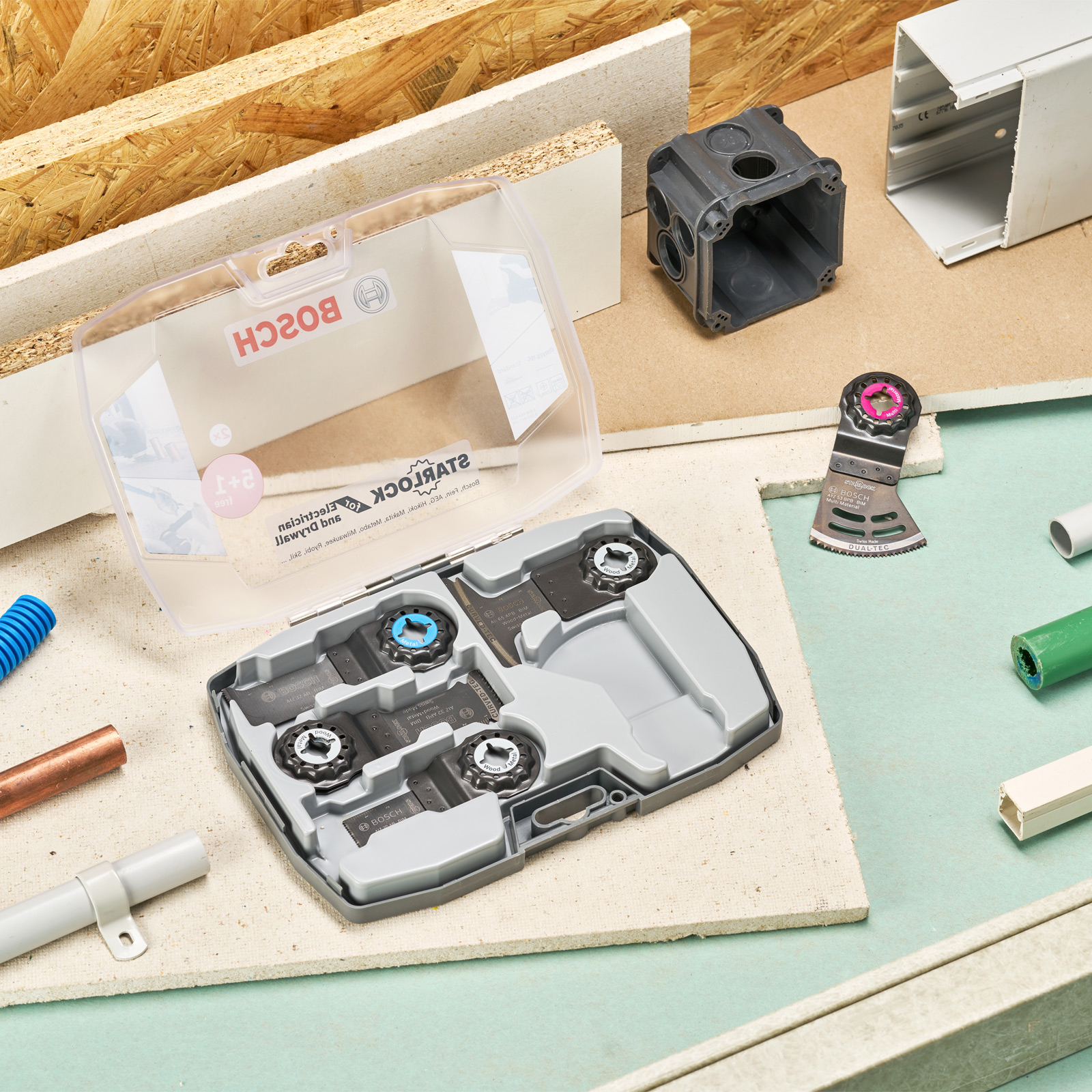 Een gereedschapsset met verschillende bladen en accessoires op een getextureerde achtergrond.