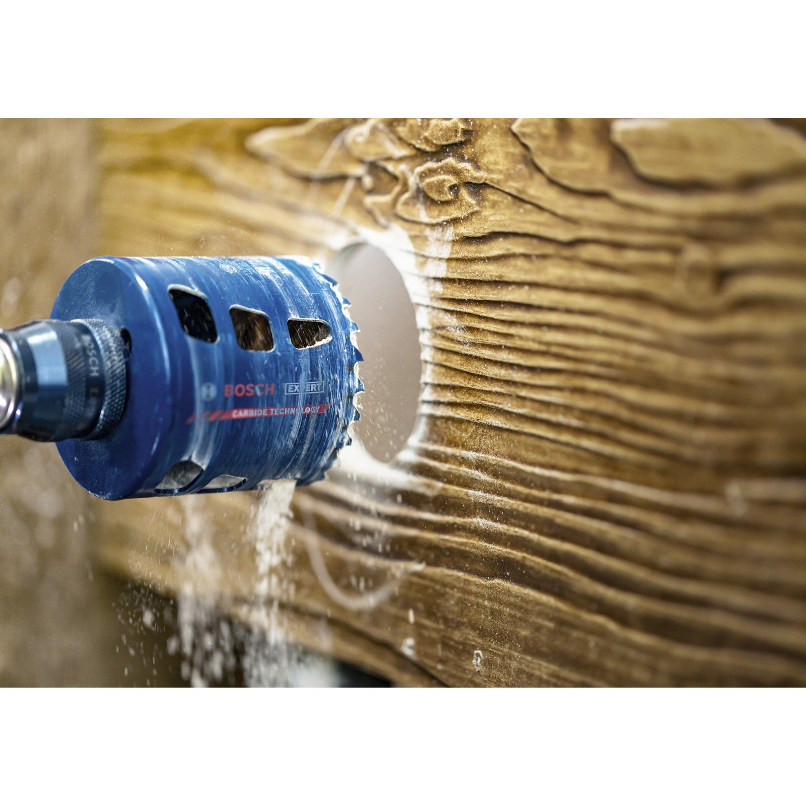 Wiertło wiercące otwór w drewnianym materiale.