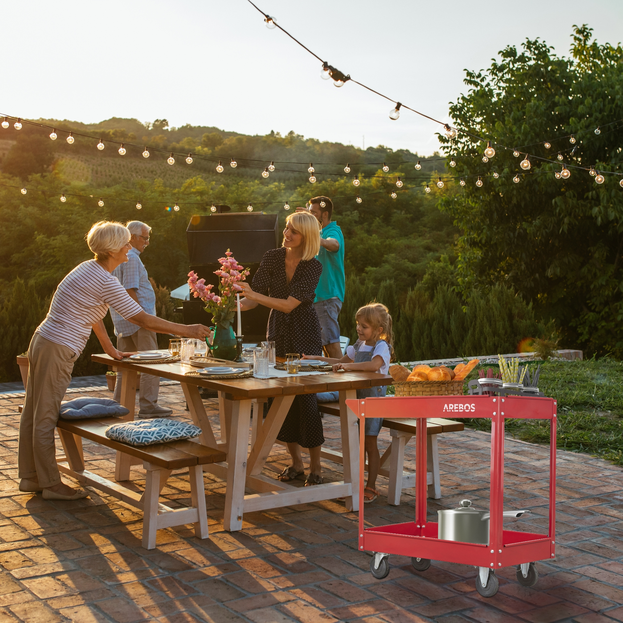 Familie bei einer Gartenparty. Leute um einen Tisch, ein roter Wagen und Lichterketten. Grüne Bäume im Hintergrund.