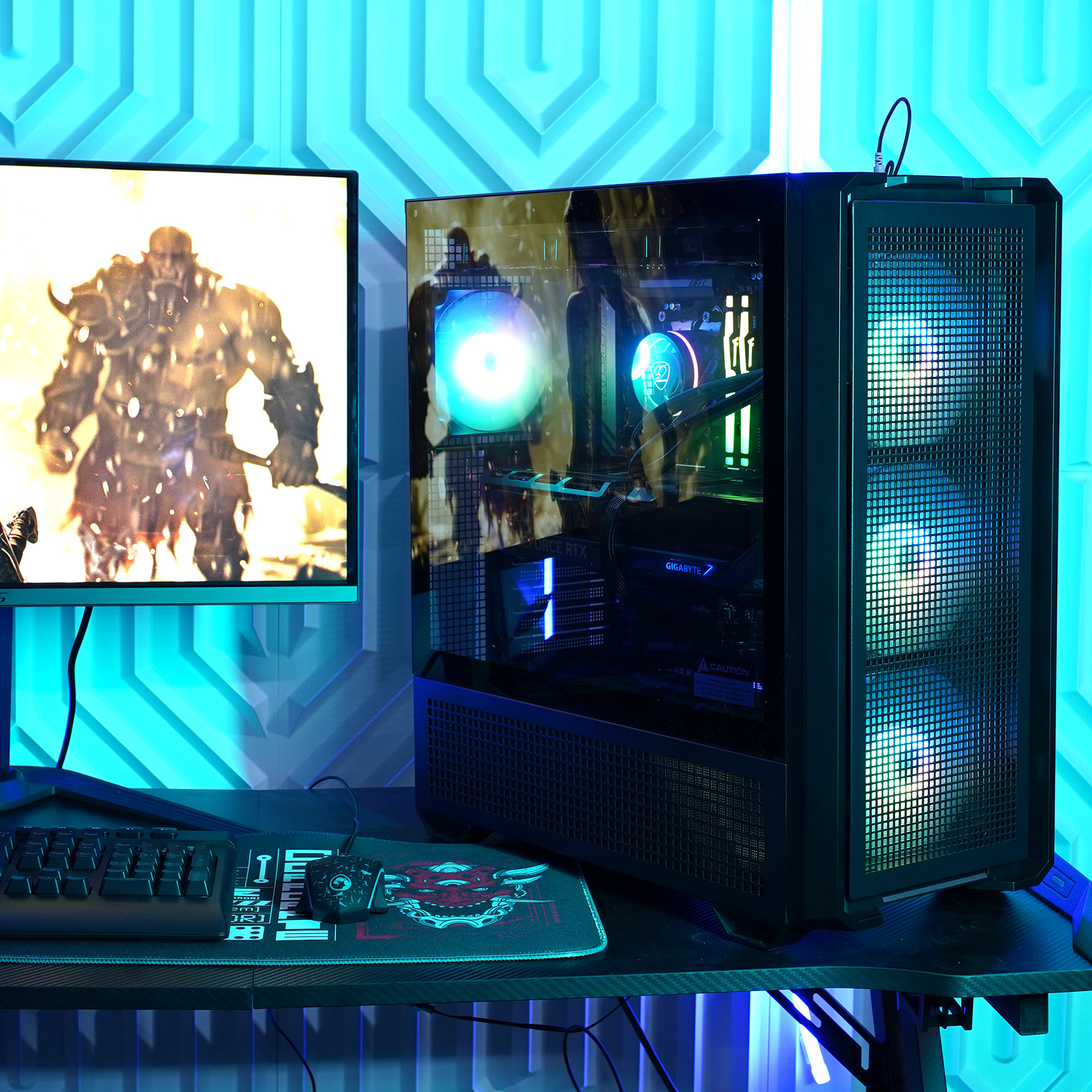 Gaming-Setup mit Computergehäuse, Monitor, Tastatur, Maus und blauer Umgebungsbeleuchtung.