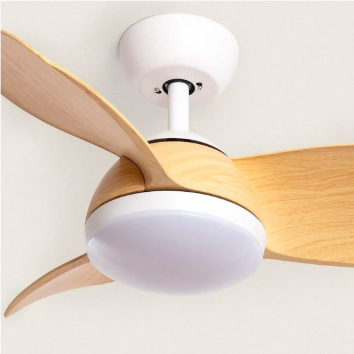 Un ventilatore da soffitto con tre pale in legno, una luce e una base bianca. Sfondo bianco.