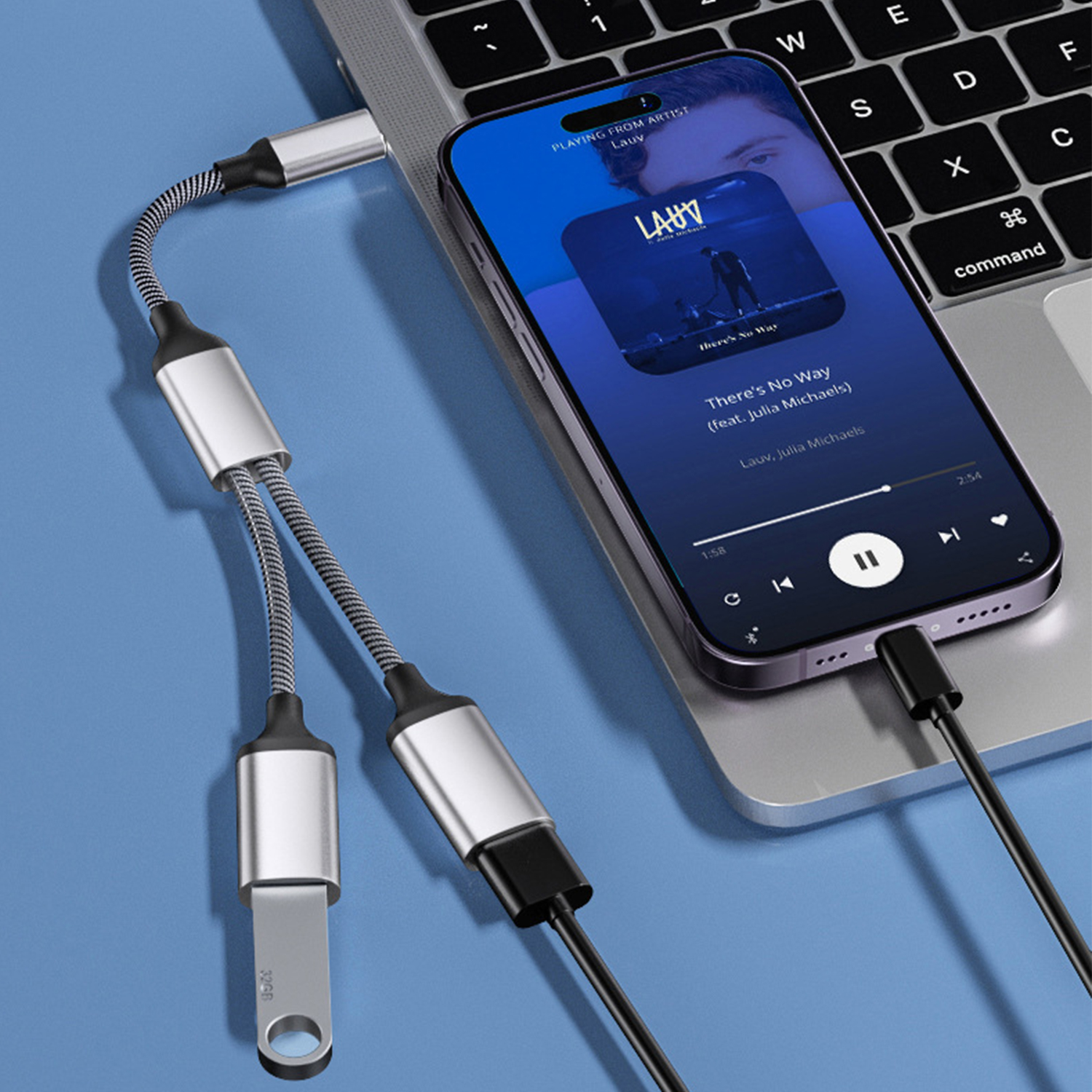 Un laptop con un telefono collegato. Il telefono riproduce musica e ha una porta USB.