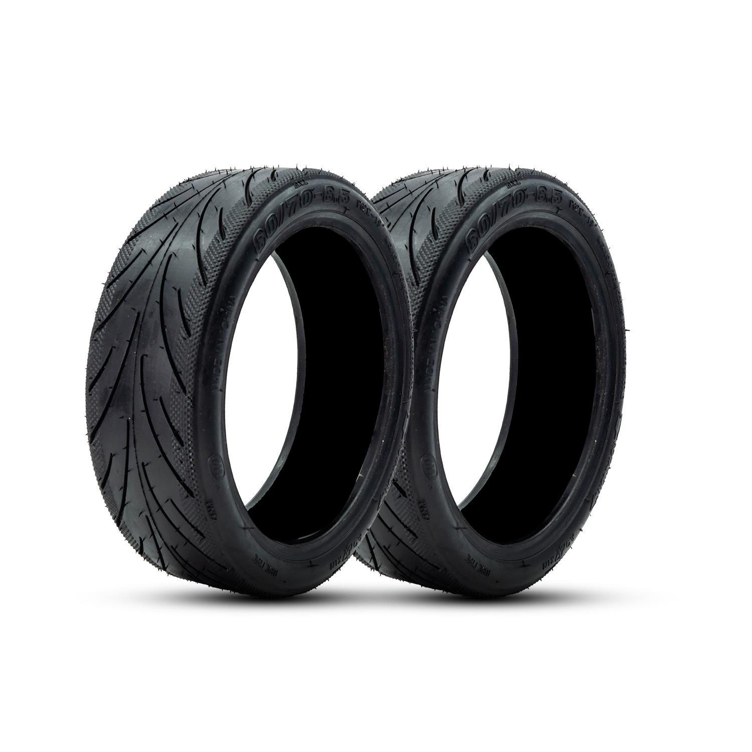 Dos neumáticos negros para scooter, con patrones de banda de rodadura, aislados sobre un fondo blanco.
