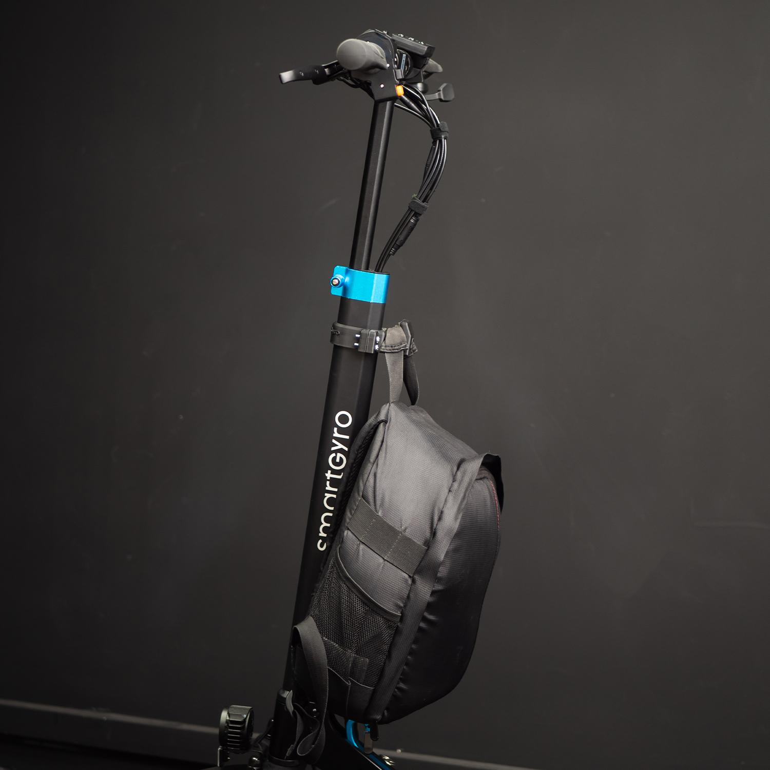 Scooter eléctrico negro y azul con una bolsa negra. El texto dice smartGyro.