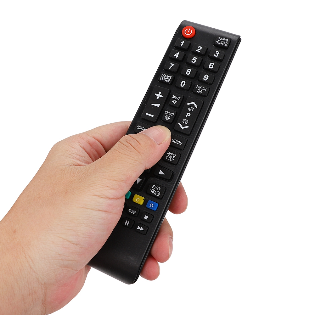 Eine Hand, die eine schwarze TV-Fernbedienung mit Zahlen und Tasten hält.