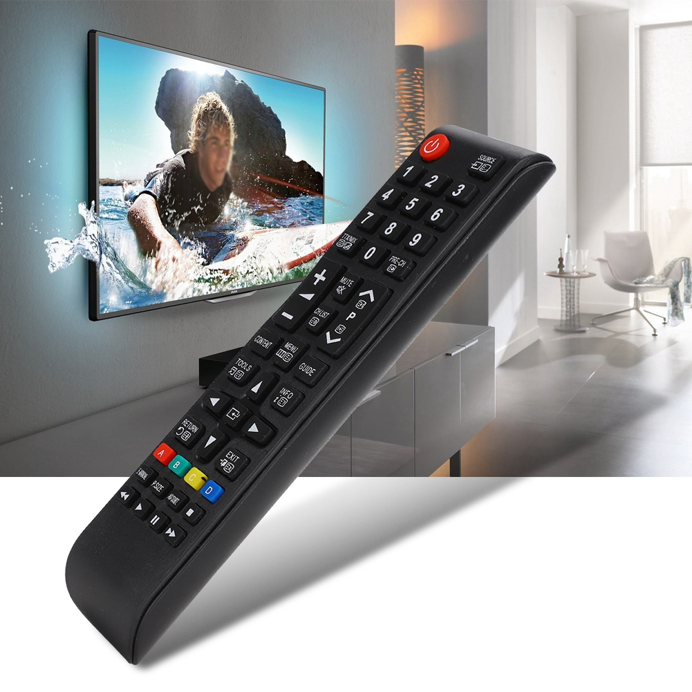 Eine Person hält eine schwarze Fernbedienung, die auf einen Fernsehbildschirm zeigt.