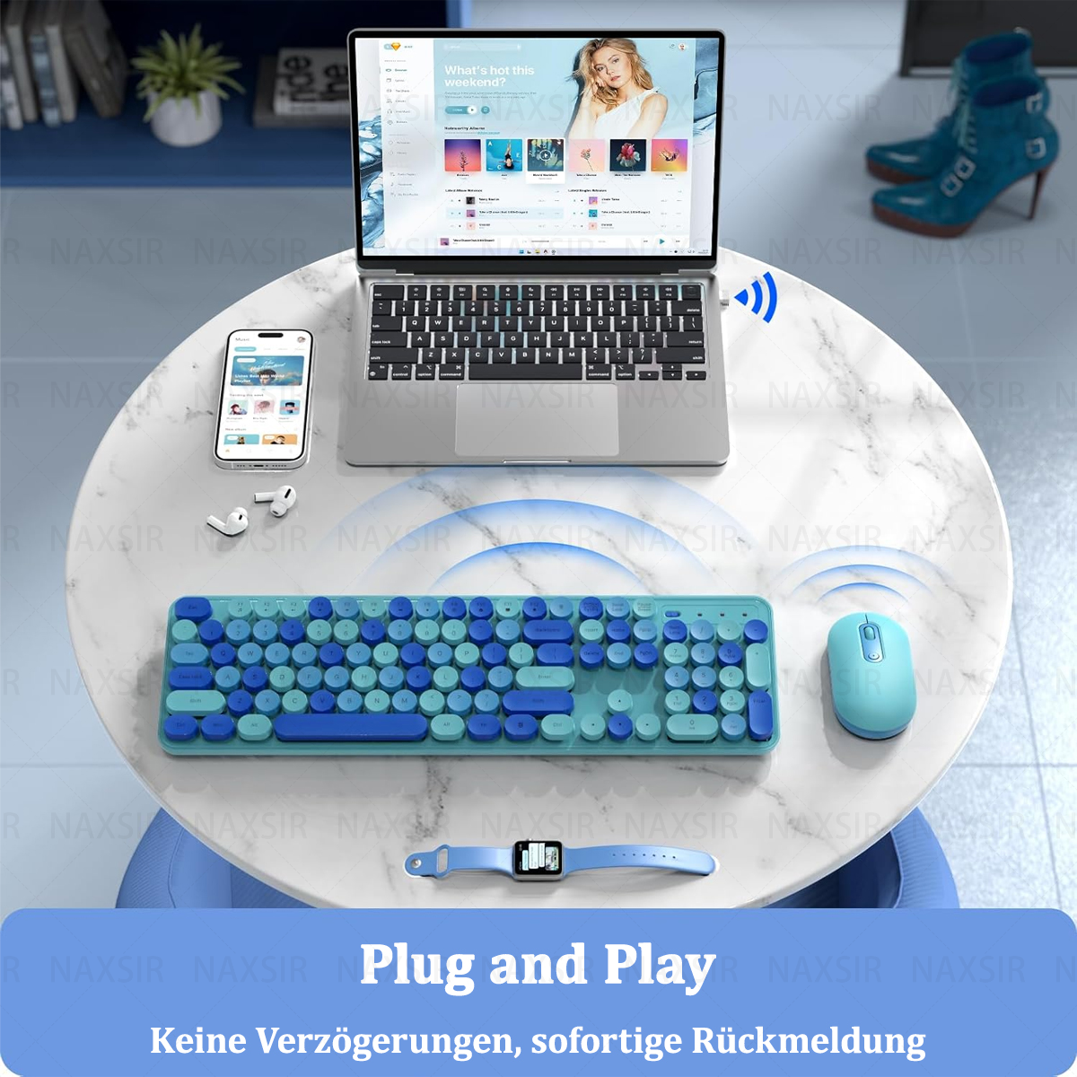 Eine blau-grüne Tastatur, Maus und Uhr auf einem weißen Tisch. Ein Laptop und Telefon sind ebenfalls vorhanden.