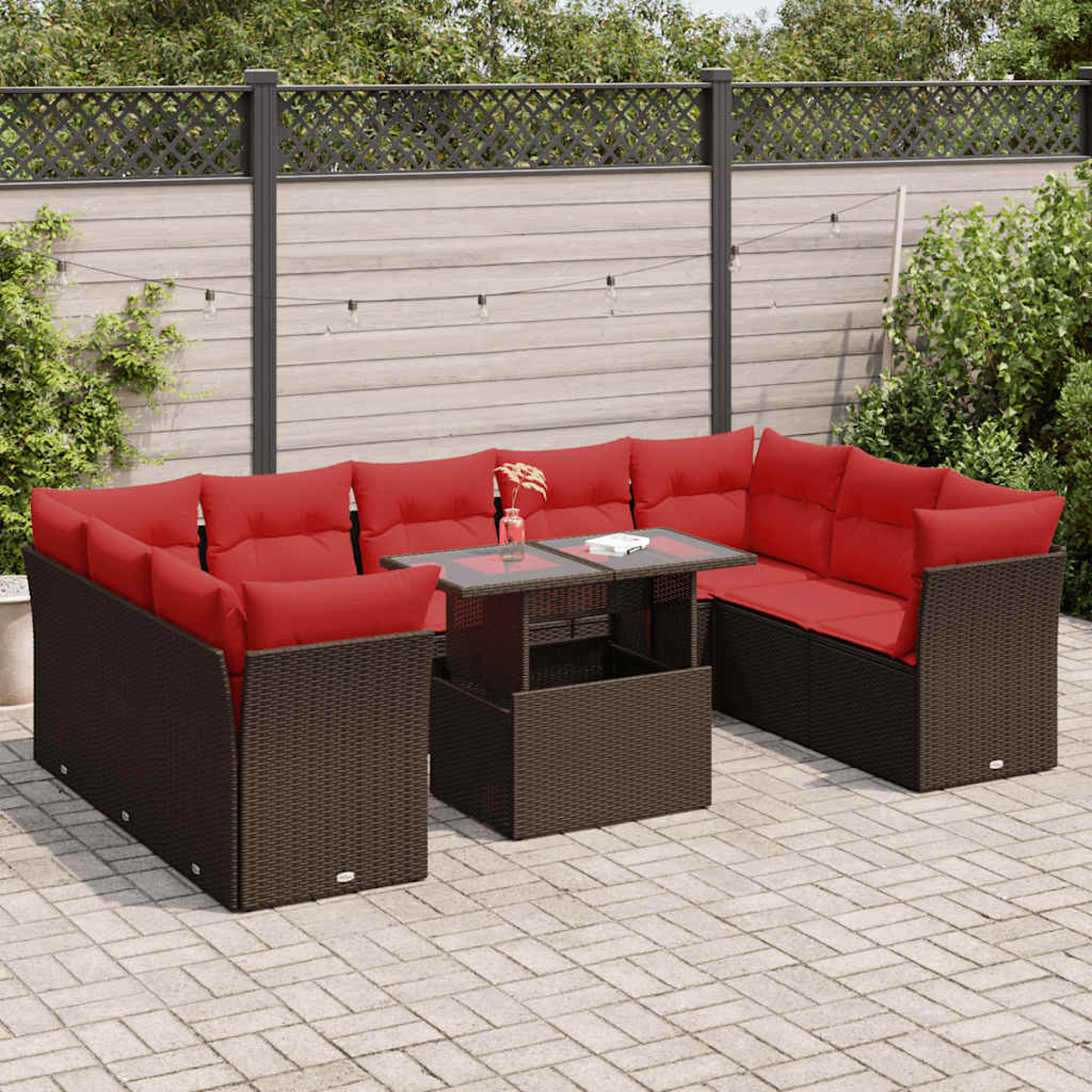 Dunkelbraunes Ecksofa aus Korbgeflecht mit roten Kissen. Enthält einen Tisch mit Glasplatte.