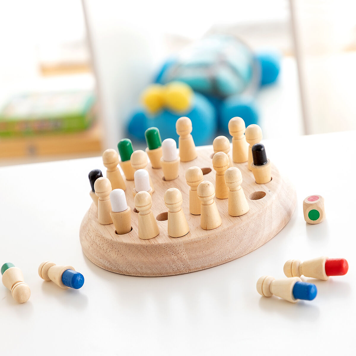 Gioco da tavolo in legno con pioli, dadi e un giocattolo blu sullo sfondo.