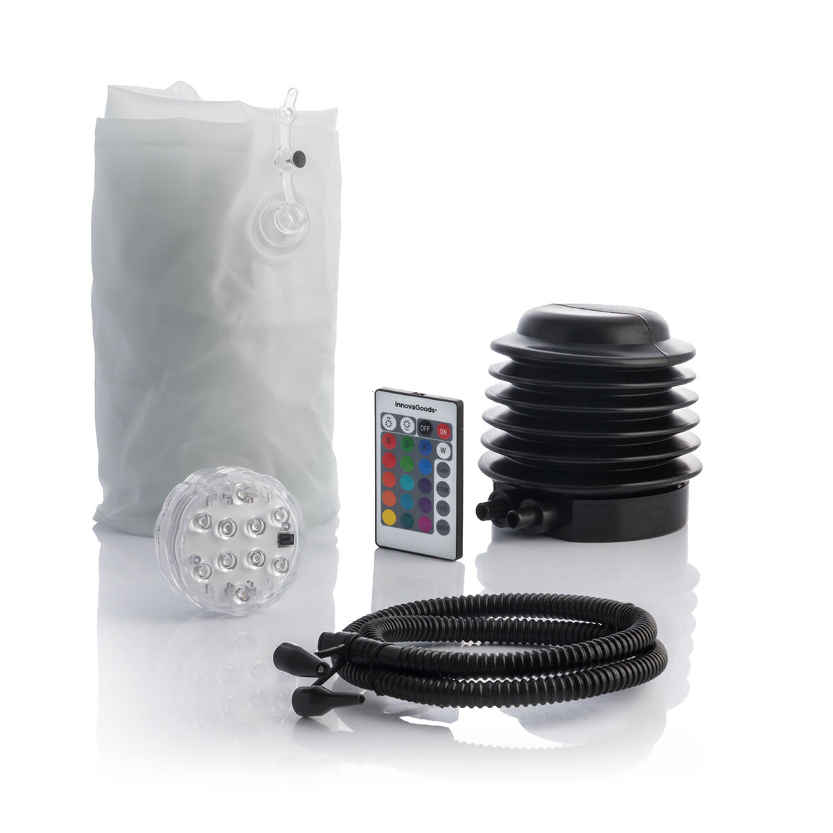 Divers accessoires de camping : boule lumineuse, télécommande, pompe et tuyaux noirs.