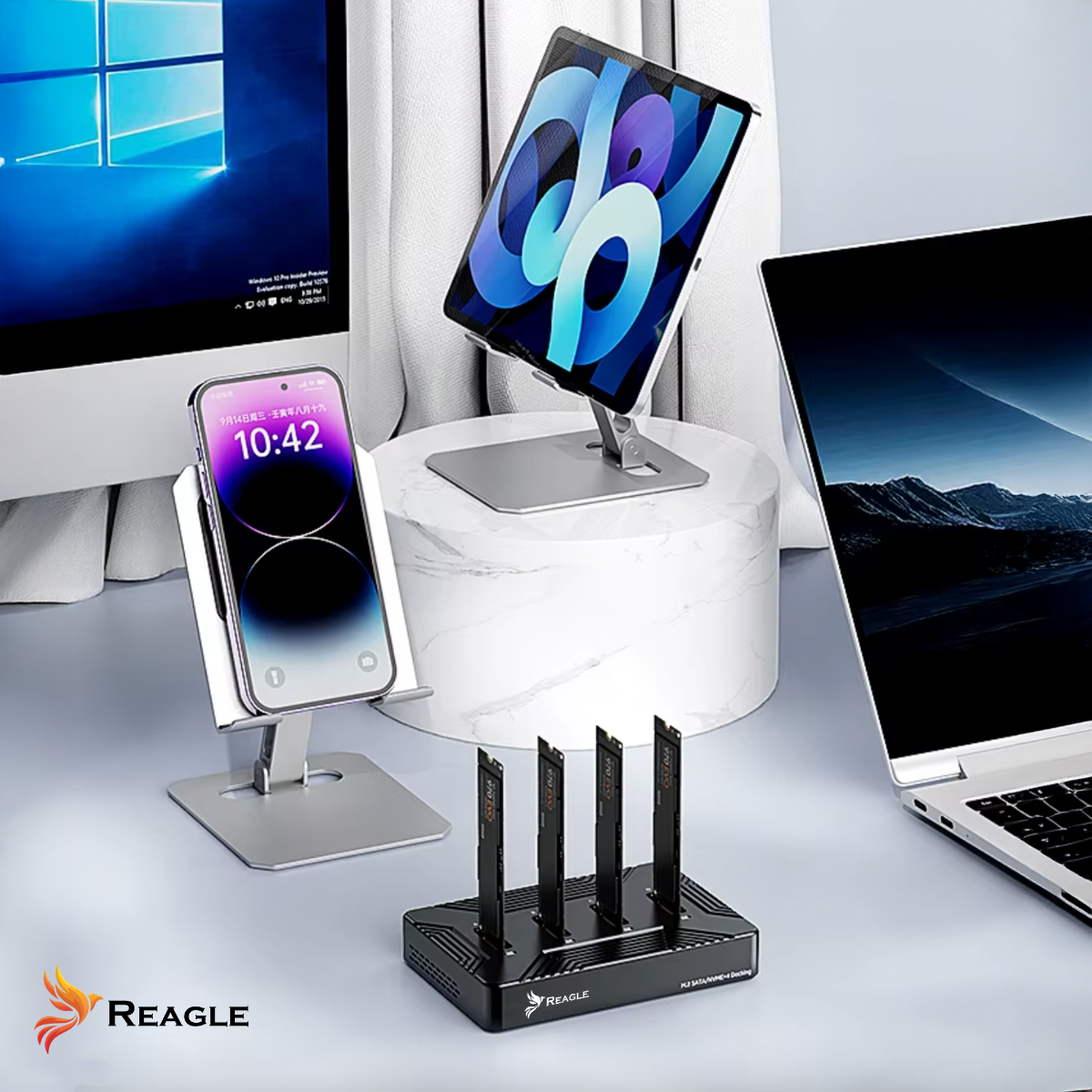 Konfiguracja biurka z telefonem, tabletem, laptopem i czarną stacją dokującą z dyskami SSD.