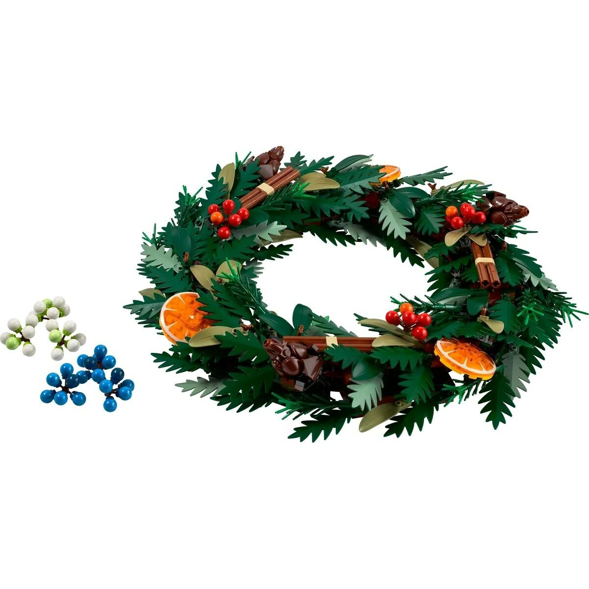 Een LEGO-krans met groene bladeren, rode bessen, sinaasappelschijfjes en kaneelstokjes. Enkele LEGO-accessoires liggen opzij.