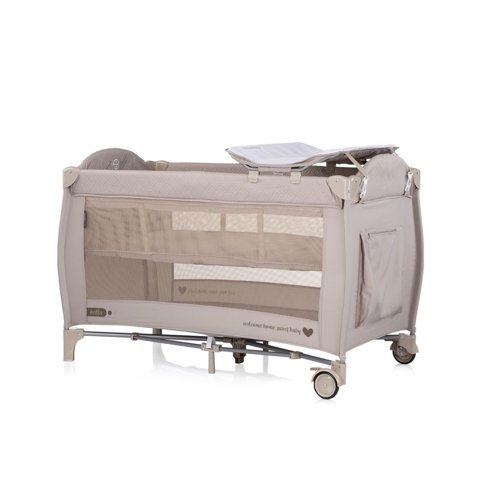 Beiges Babybett mit Mesh-Seiten und Wickelstation. Es hat Räder und ein Mobile darüber.