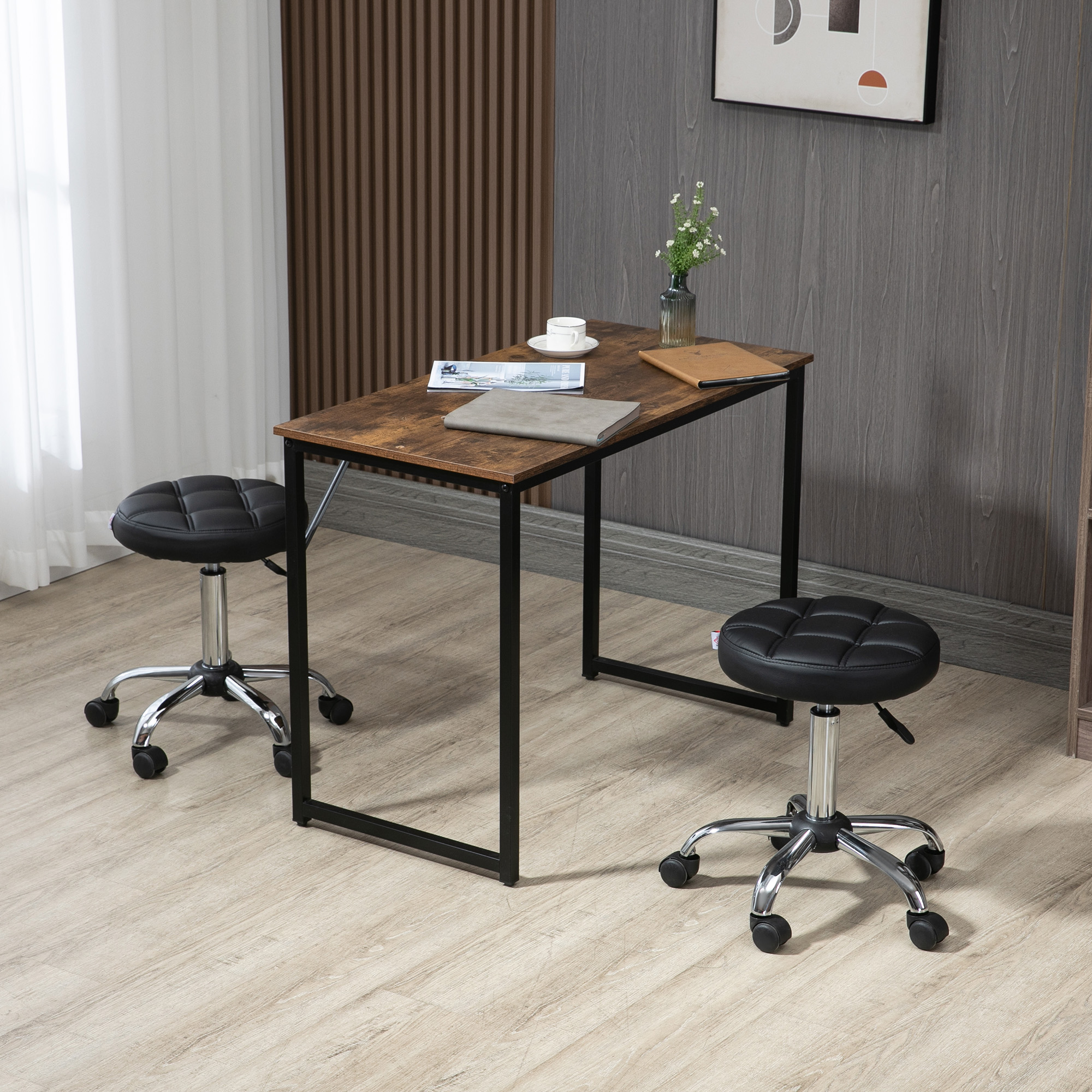 Ein Schreibtisch mit zwei Hockern. Der Schreibtisch hat eine Holzplatte und schwarze Beine. Die Hocker sind schwarz.