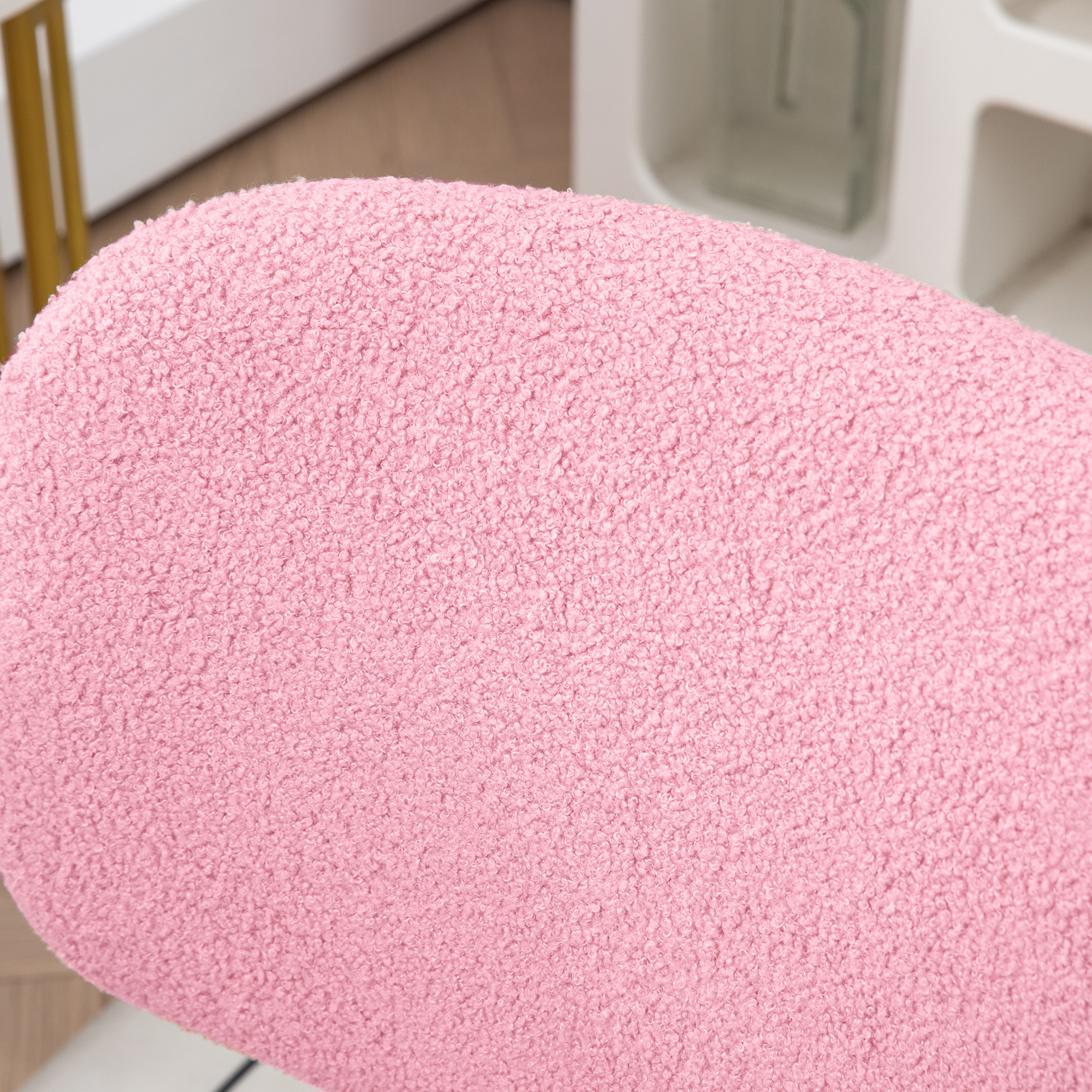 Nahaufnahme einer rosa, strukturierten Stuhllehne. Die Textur scheint ein flauschiger Stoff zu sein.