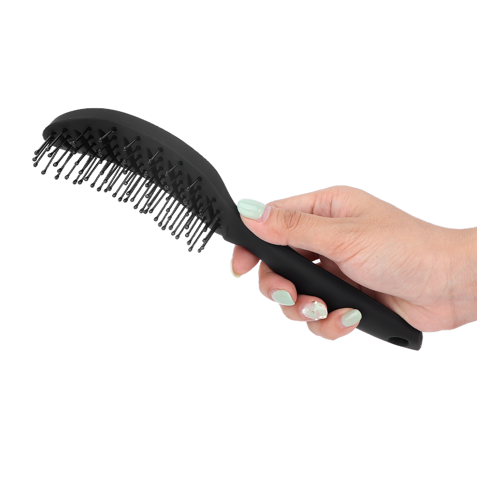 Eine Hand, die eine schwarze Haarbürste hält. Die Bürste ist oval mit Borsten. Die Hand hat lackierte Nägel.