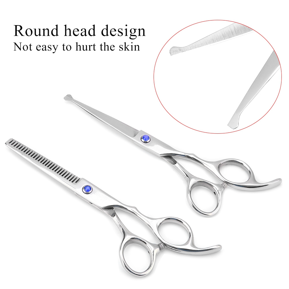Zwei silberne Friseurscheren mit runder Spitze, eine mit gezahnter Kante, auf weißem Hintergrund.
