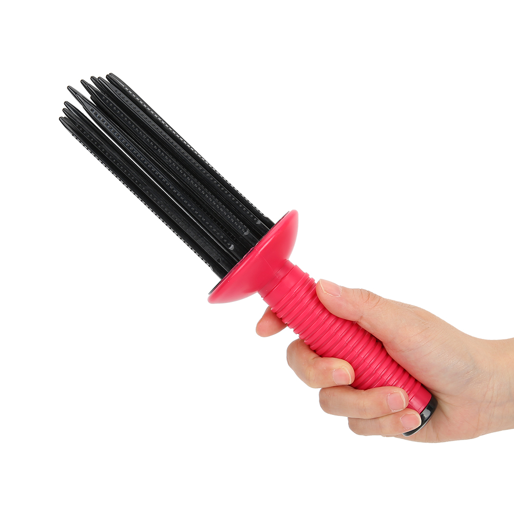 Ein rotes Haarstyling-Werkzeug in der Hand gehalten. Es hat schwarze Borsten.