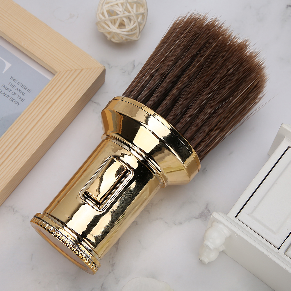 Goldener Friseur-Nackenpinsel mit dunkelbraunen Borsten und einem kleinen weißen Objekt.