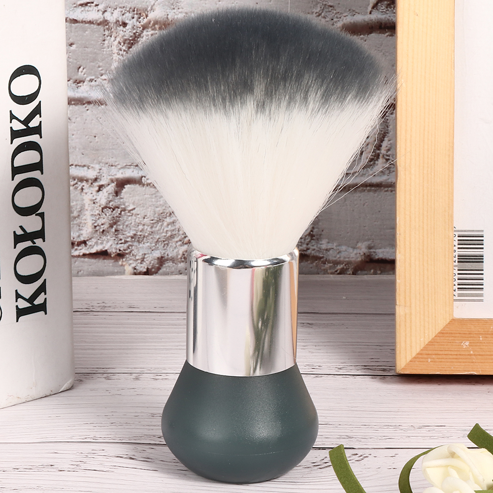 Make-up-Pinsel mit weißen und grauen Borsten und einem dunkelgrünen Griff, vor weißem Hintergrund.