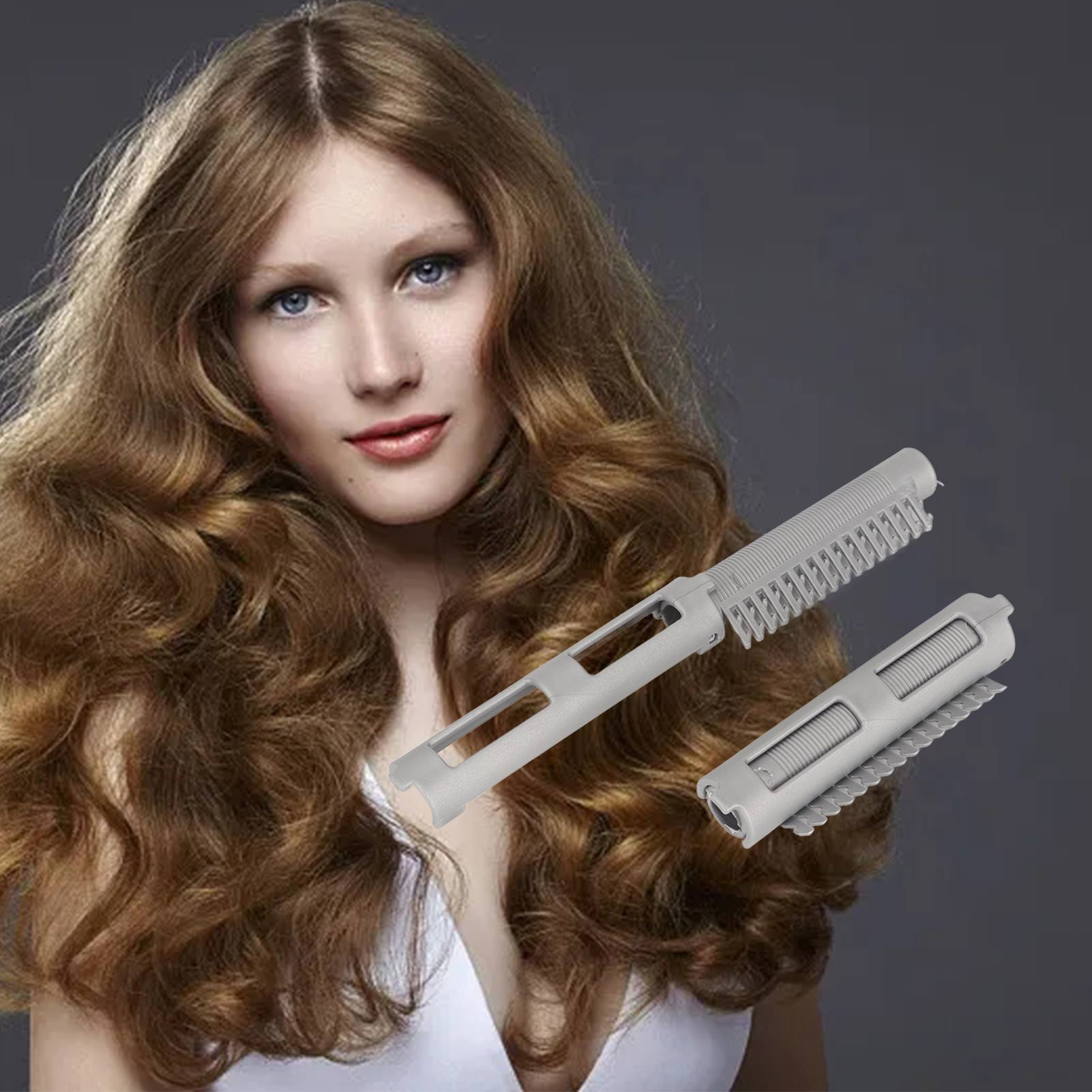 Frau mit langen, welligen, braunen Haaren, die zwei graue Haarroller hält, vor grauem Hintergrund.