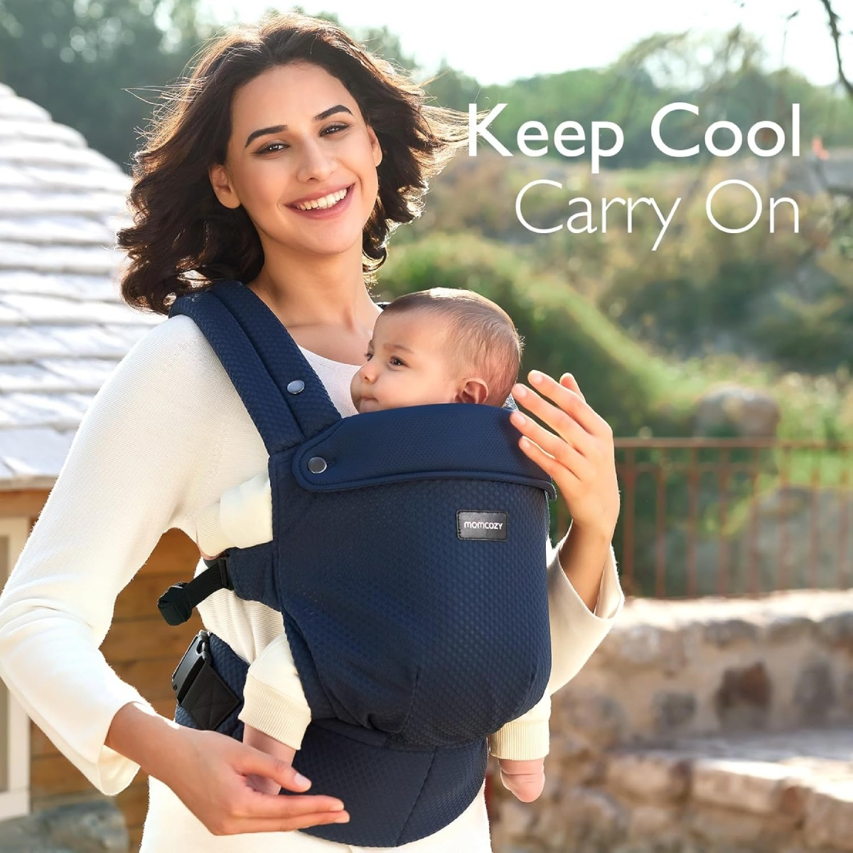 Frau trägt Baby in blauem Träger. Text: 'Keep Cool Carry On'. Sie sind draußen in einem Park.