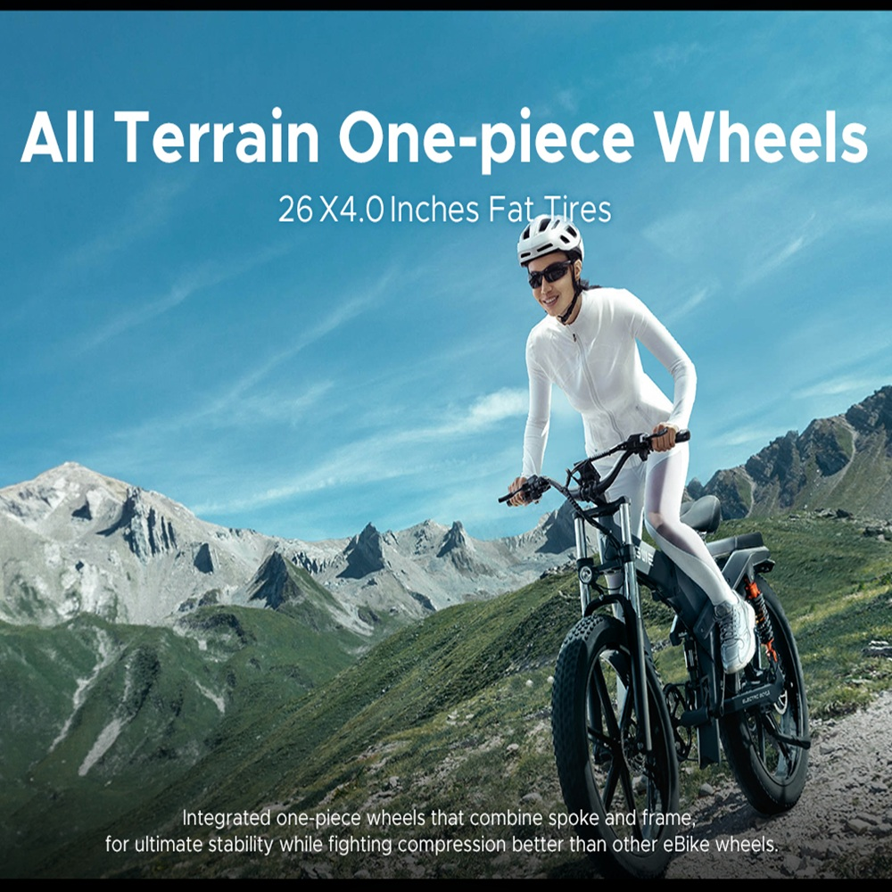 Mujer montando una e-bike negra en un camino de montaña, con texto 'All Terrain One-piece Wheels'. Montañas y cielo azul.