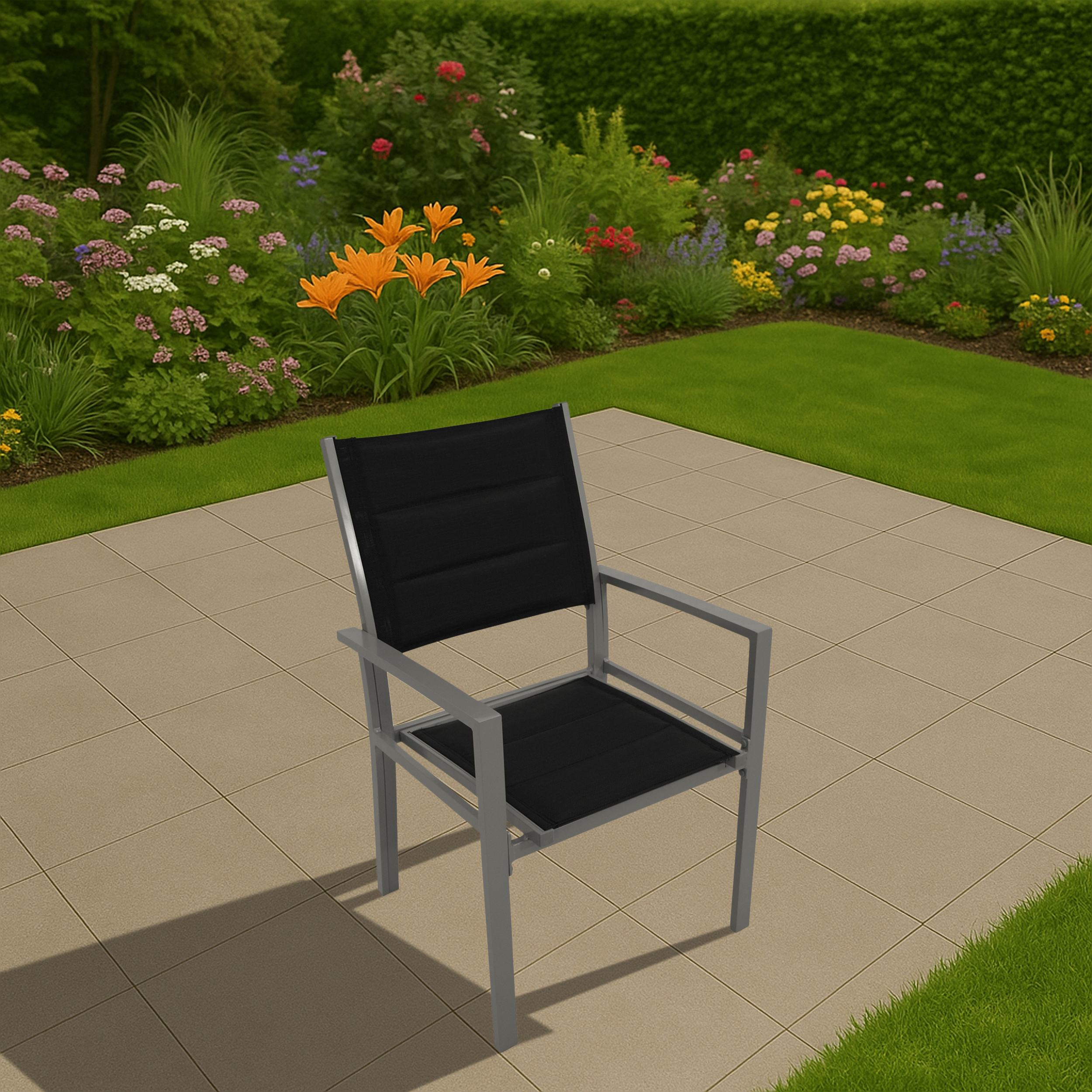 Ein silberner Stuhl mit einem schwarzen Kissen auf einer Terrasse, mit Gras und Blumen im Hintergrund.