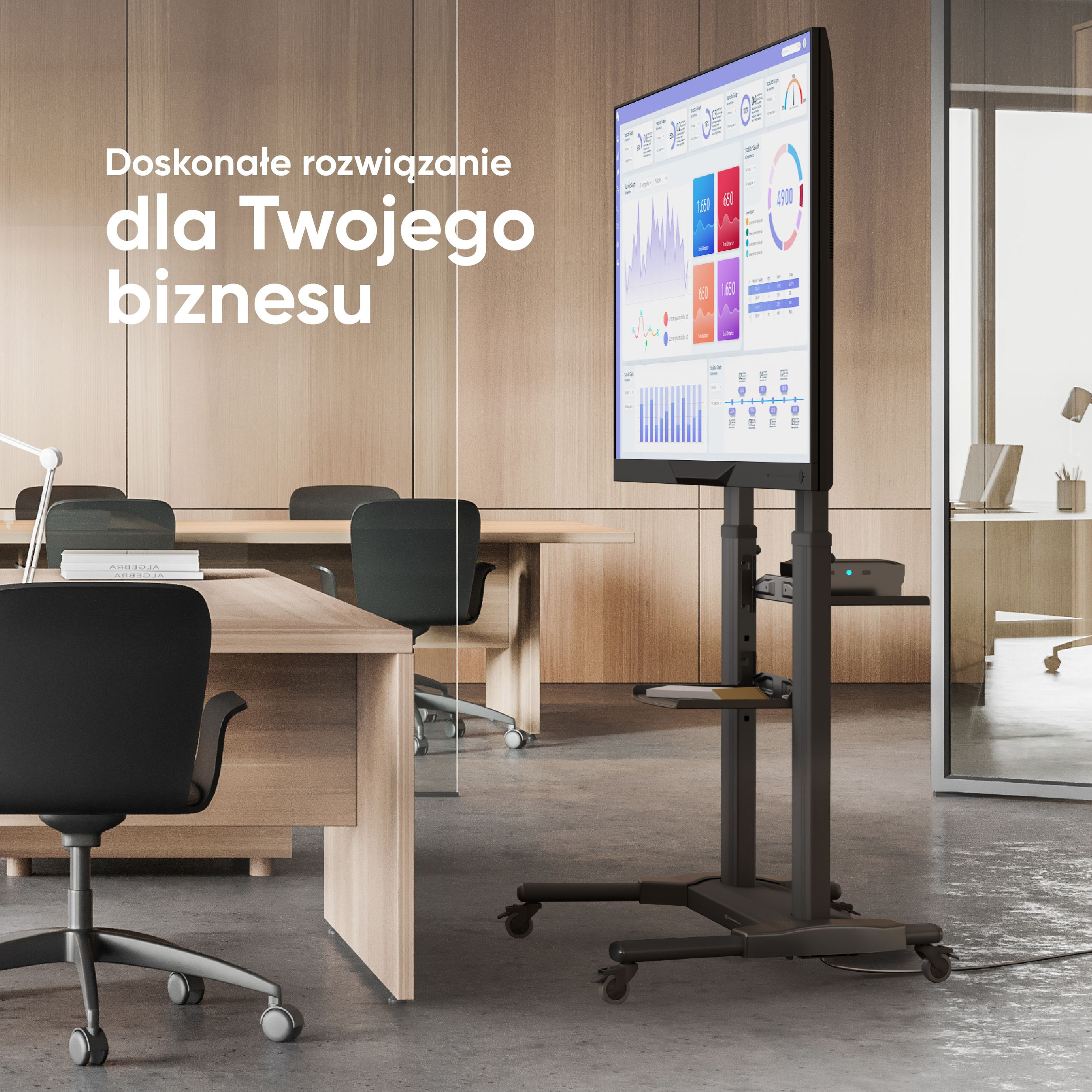 Telewizor na stojaku w otoczeniu biurowym. Biurko i krzesła są na pierwszym planie.