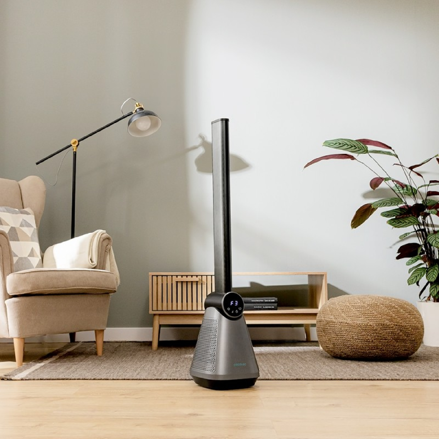 Un ventilador moderno en una habitación con muebles y una planta de interior.