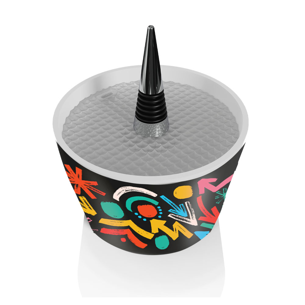 Un tappo per bottiglia bianco e nero in un contenitore nero e decorato su bianco.