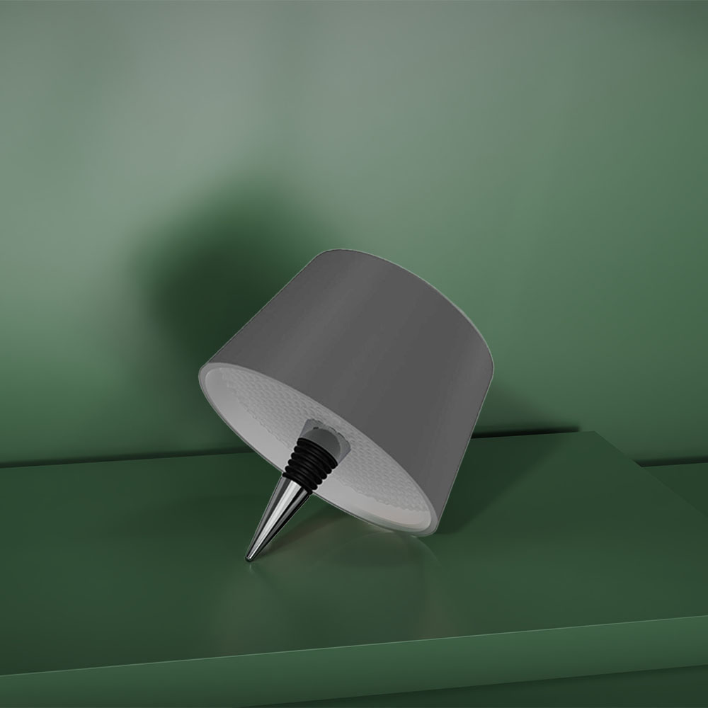 Paralume grigio con stelo nero e interno bianco riflettente, su sfondo verde.