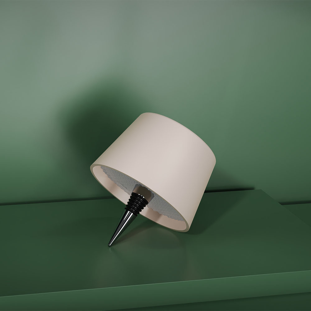 Una lampada con paralume bianco su una superficie verde. La base è un tappo per vino.