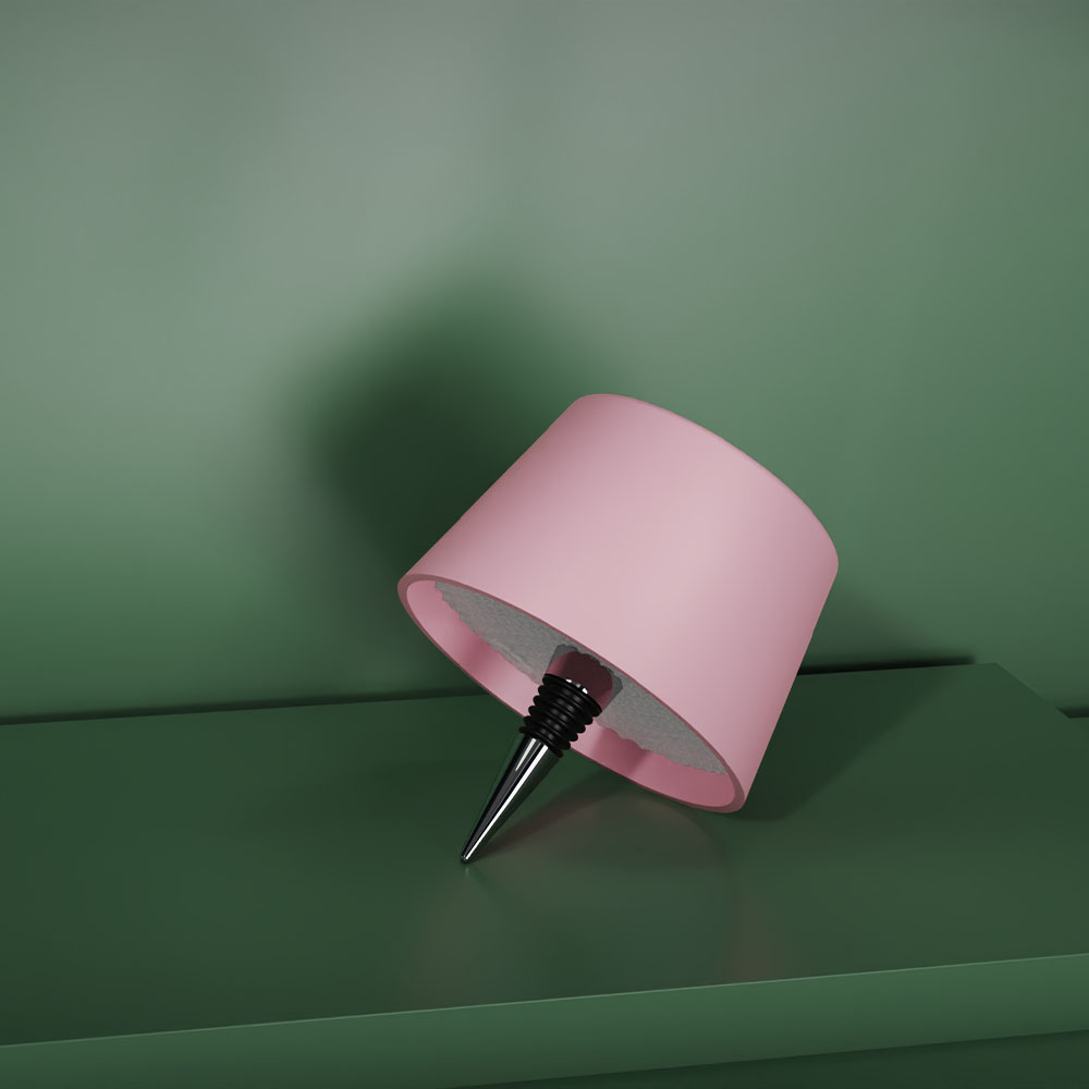 Un paralume rosa su una superficie verde, con un tappo per vino nero, su sfondo verde.