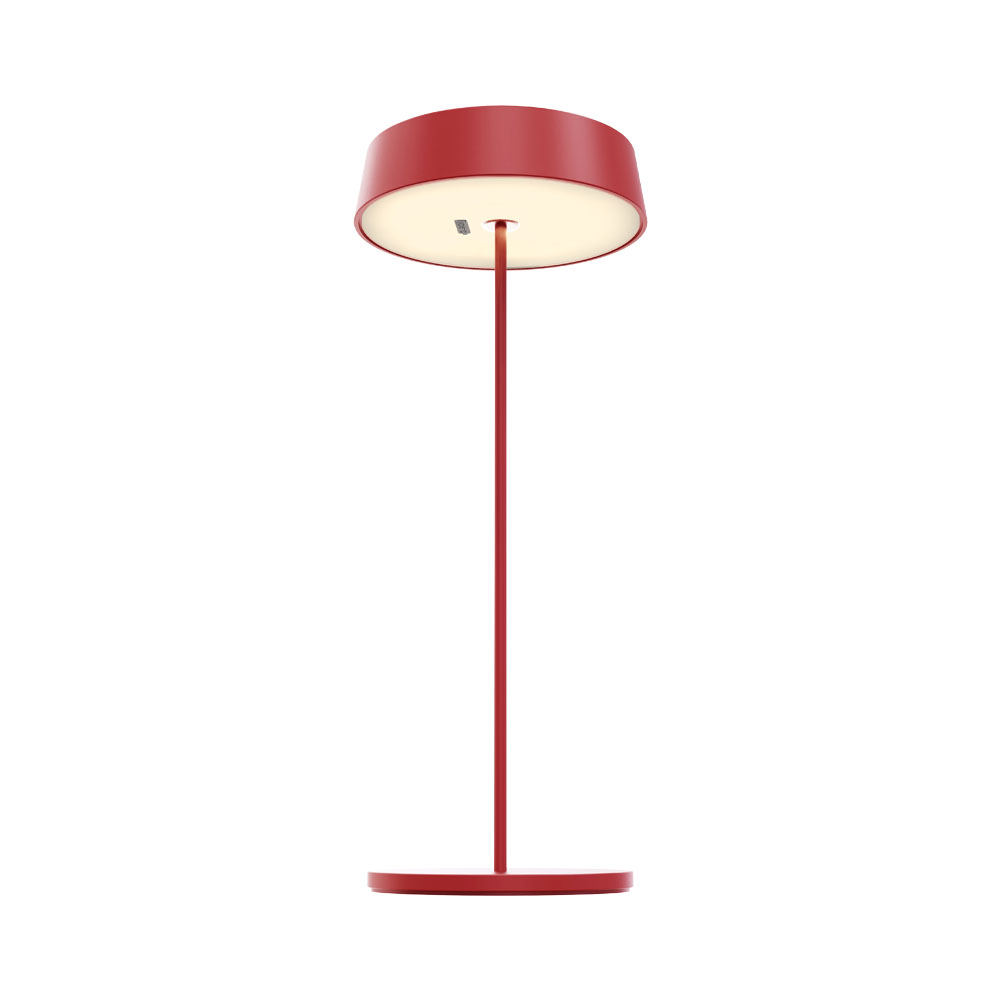Una lampada da terra rossa con base circolare, isolata su sfondo bianco.